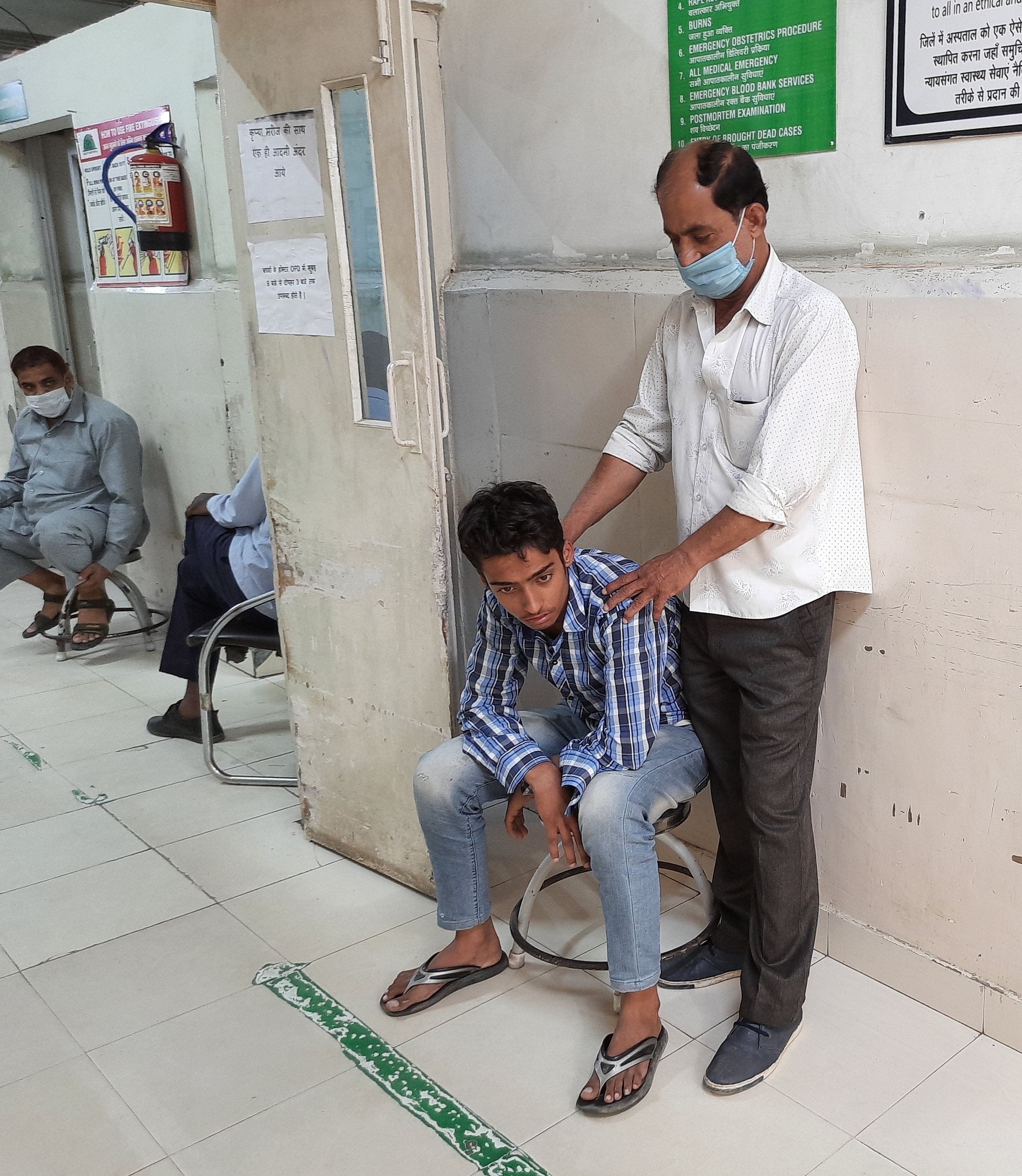 बुखार से पीड़ित बेटे के इलाज के लिए आपातकालीन वार्ड के गेट पर खड़ा सुरेंद्र। संवाद बुखार से पीड़ित बेटे के इलाज के लिए आपातकालीन वार्ड के गेट पर खड़ा सुरेंद्र। संवाद
