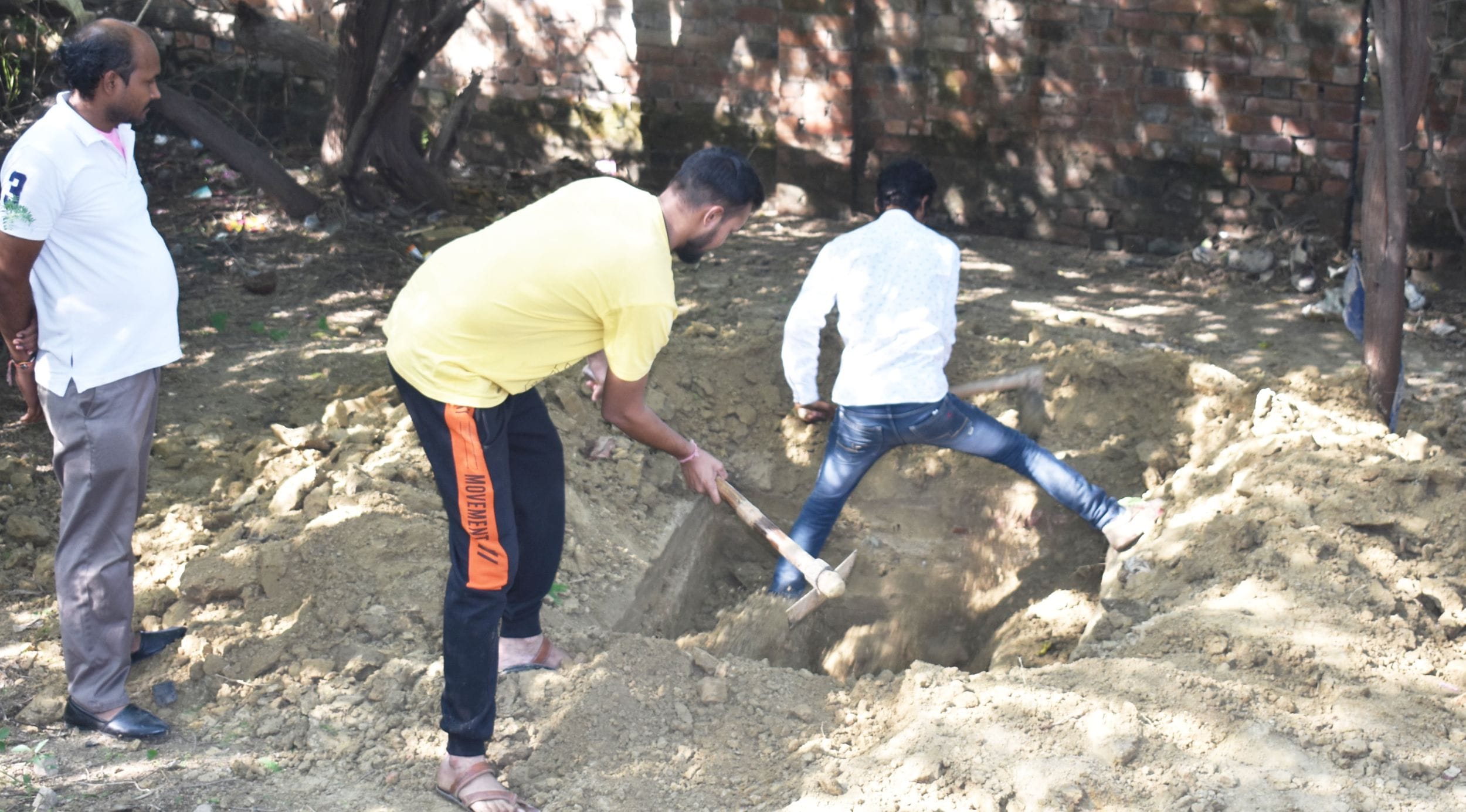 शव दफन करने के लिए खोदी गई कब्र को पूरते लोग। संवाद शव दफन करने के लिए खोदी गई कब्र को पूरते लोग। संवाद