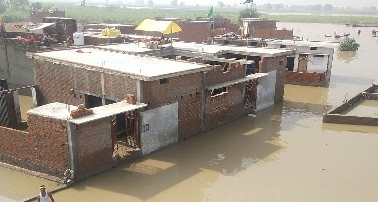 शहर के मोहल्ला बेनी चौधरी में बाढ़ के पानी से घिरे घर, लोगों ने छत की ली शरण।
