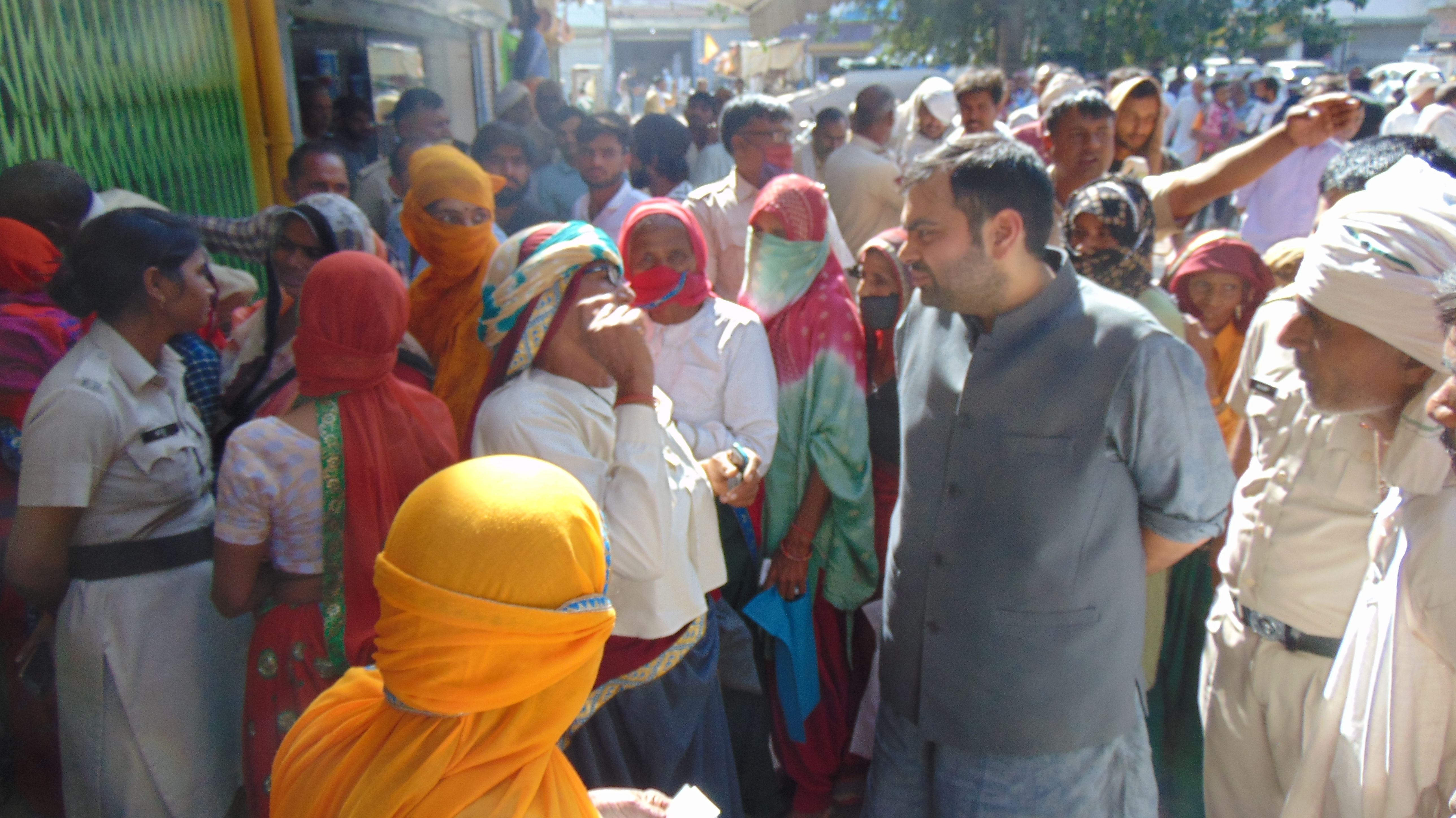 खाद केंद्र के बाहर खड़ी महिलाओं से बातचीत करते रेवाड़ी विधायक चिरंजीव राव। संवाद खाद केंद्र के बाहर खड़ी महिलाओं से बातचीत करते रेवाड़ी विधायक चिरंजीव राव। संवाद