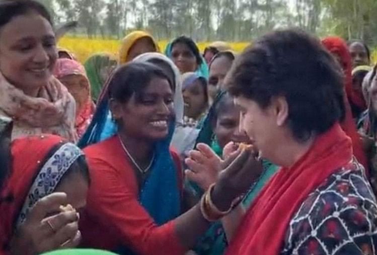 प्रियंका गांधी को पराठा खिलाती एक महिला किसान।