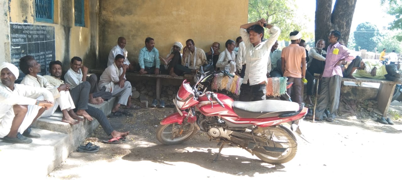 डोंगराखुर्द में दुकान के बाहर बैठे किसान
