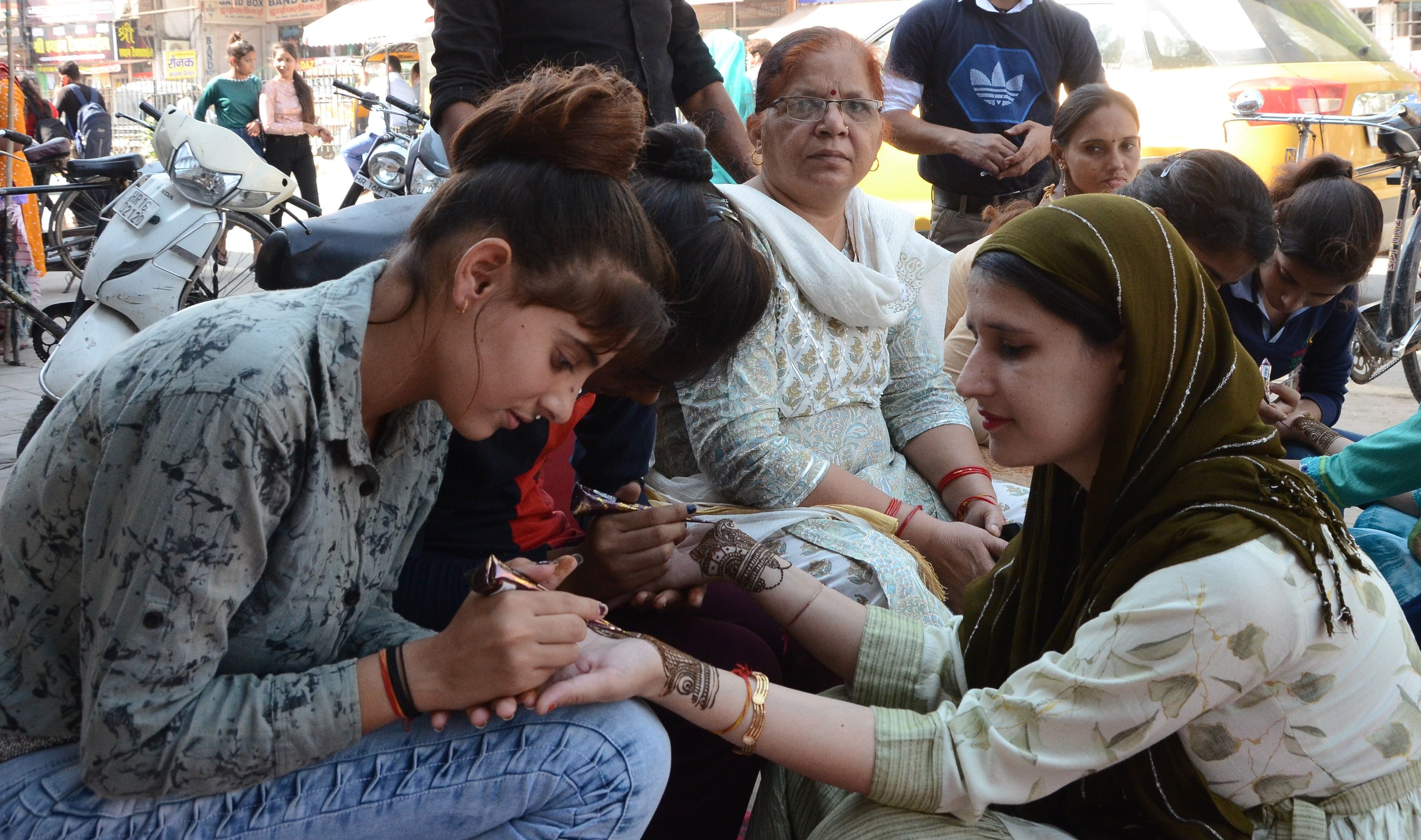 सजना है मुझे सजना के लिए....। करवाचौथ पर्व को लेकर हाथों में मेंहदी सजवाती सुहागिन। संवाद