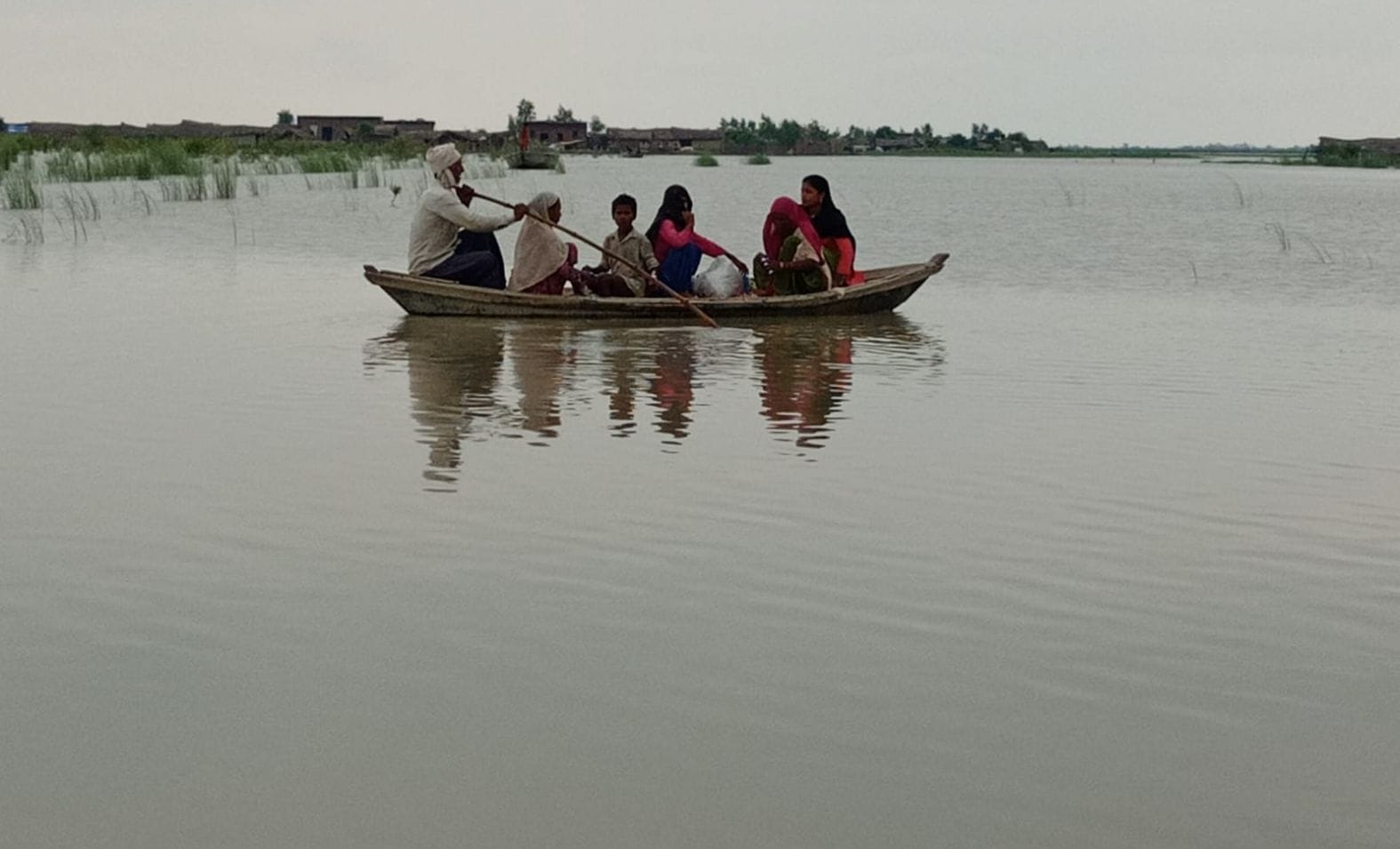 शमसाबाद के गांव कटरी तौफीक में बाढ़ का पानी भरने से नाव से जाते ग्रामीण। संवाद