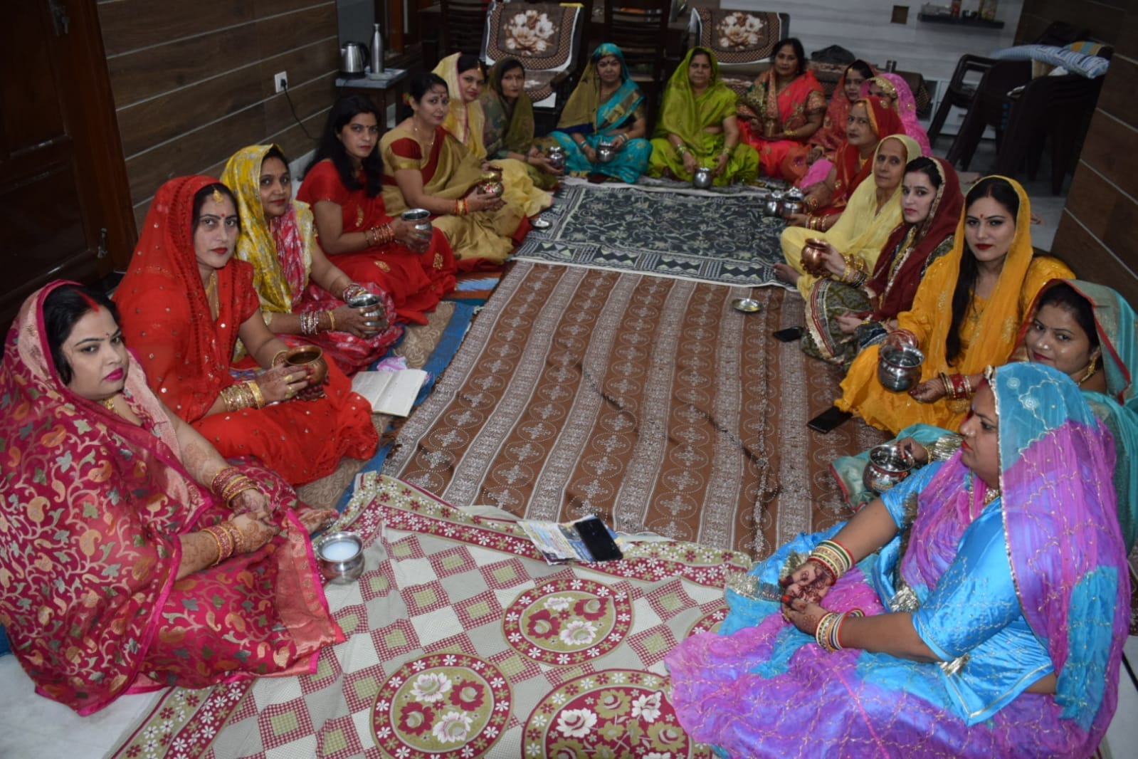 बागपत के गर्ग एंक्लेव में करवाचौथ पर्व पर कथा सुनती महिलाएं