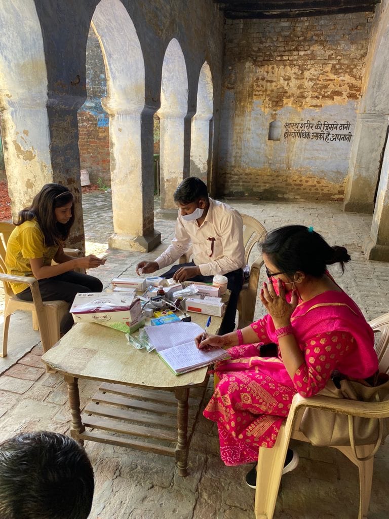 फुलेरा गांव में  आयोजित स्वास्थ्य शिविर में मरीज के स्वास्थ्य की जांच करते चिकित्सक