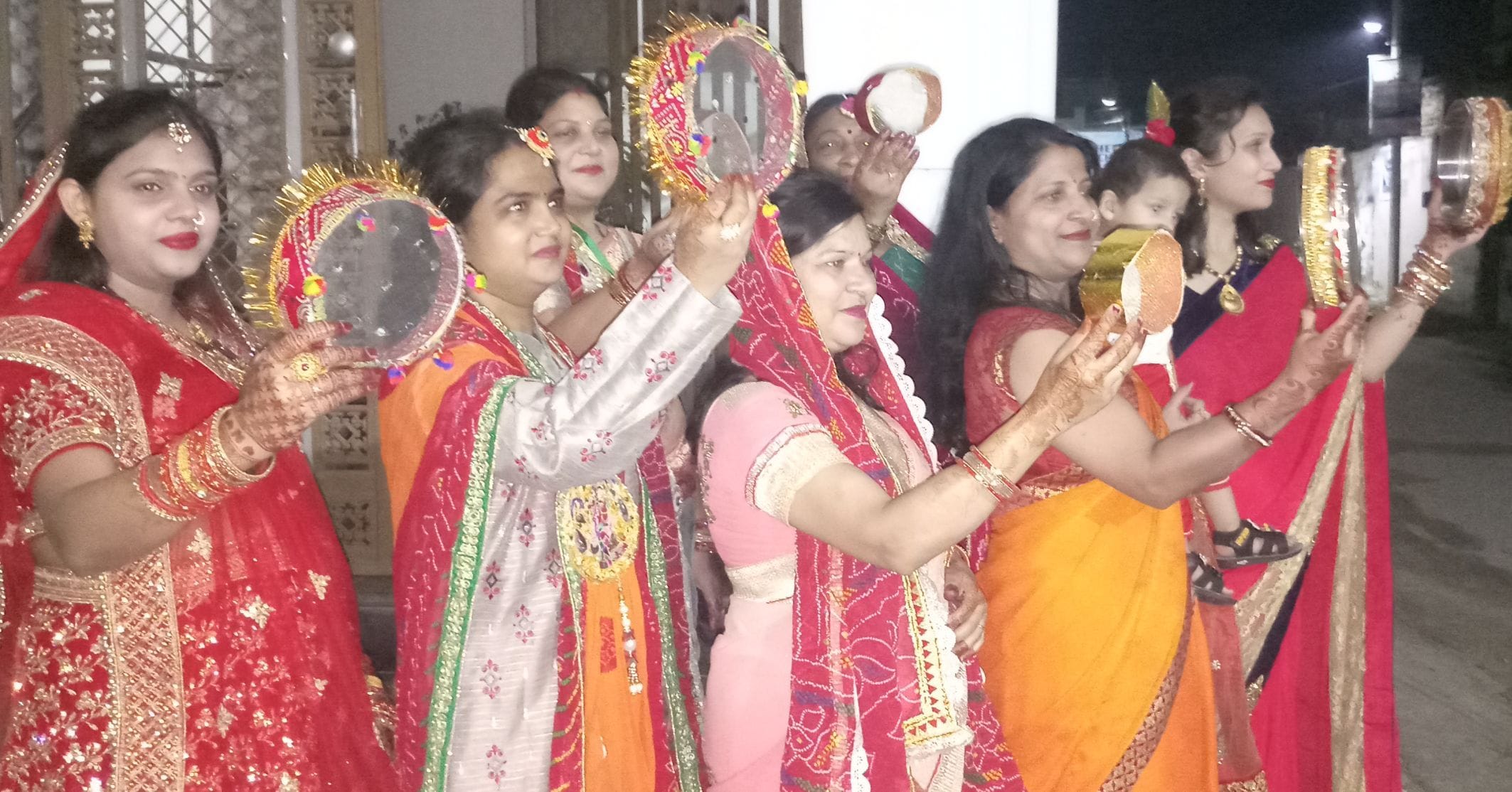 सितारगंज पुरानी मंडी कालोनी में करवाचौथ का चांद देख पति की दीर्घायु की कामना करतीं सुहागिनें।