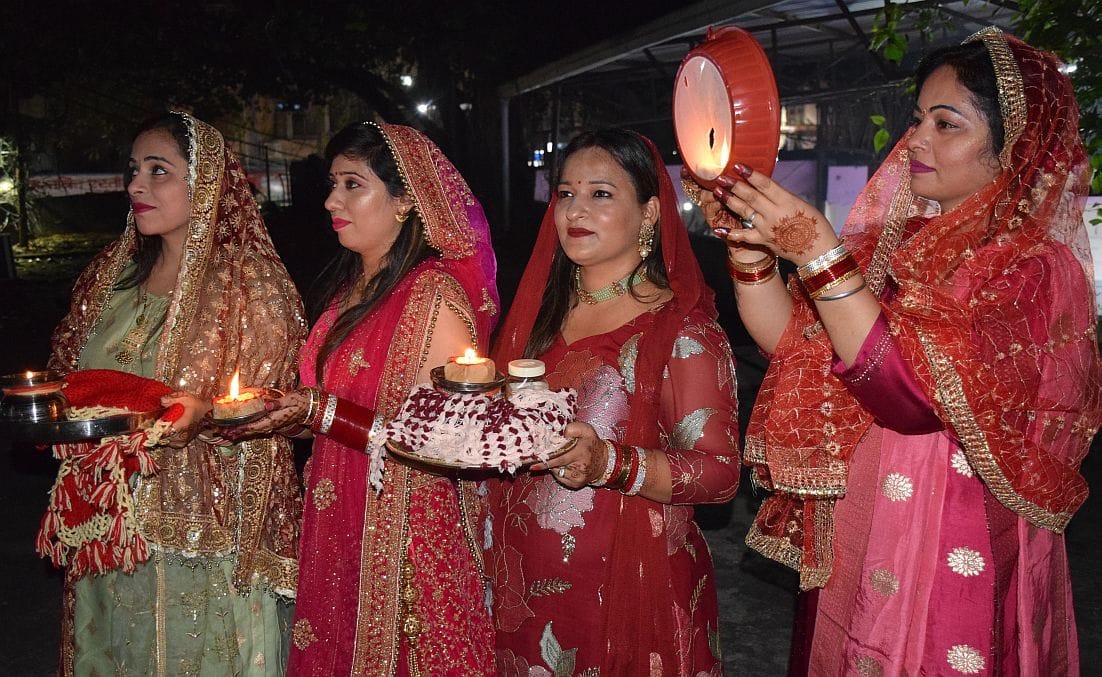 रुद्रपुर में छलनी से चांद का दीदार करतीं सुहागिनें।