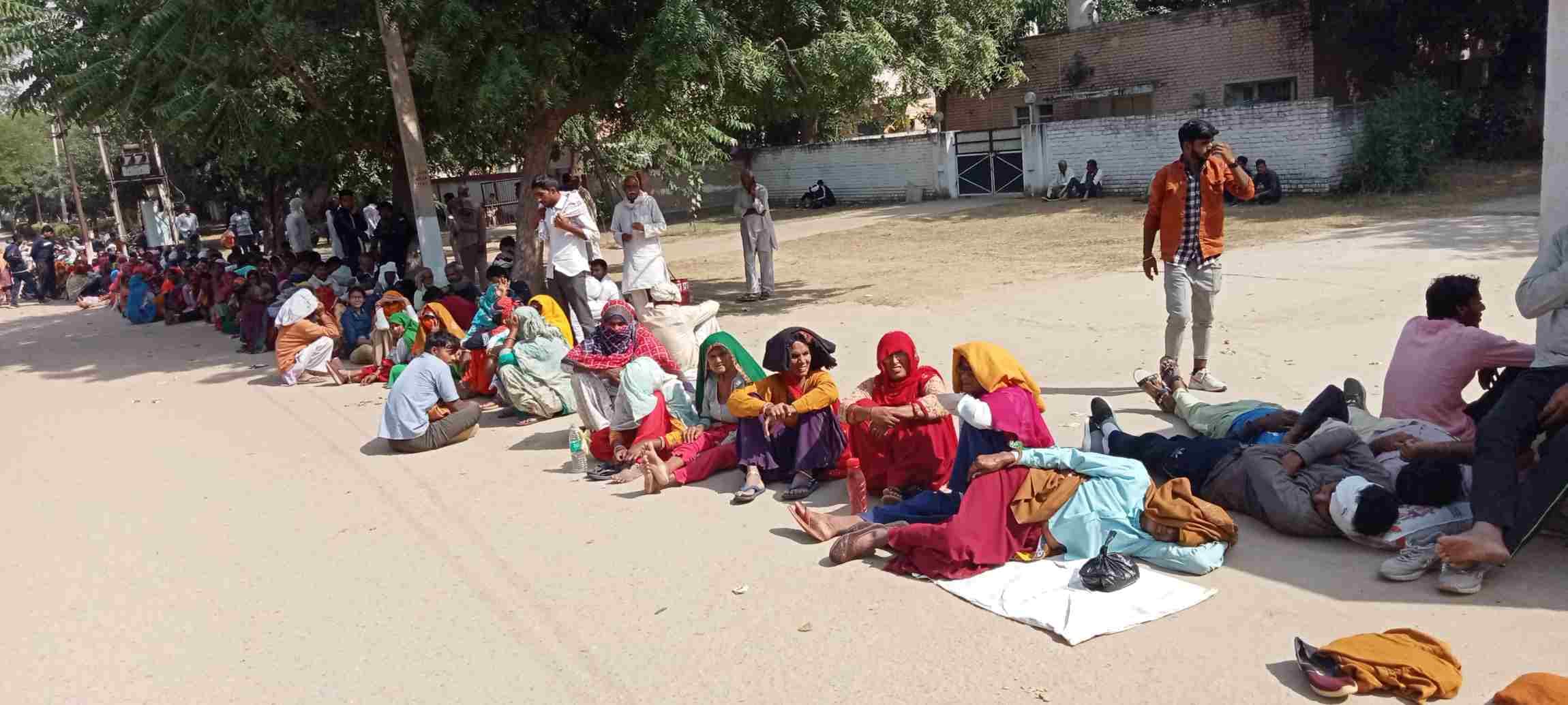 डीएपी खाद लेने के लिए पुलिस लाइन में अपनी बारी का इंतजार करते थककर सोती महिला व पुरूष । 
