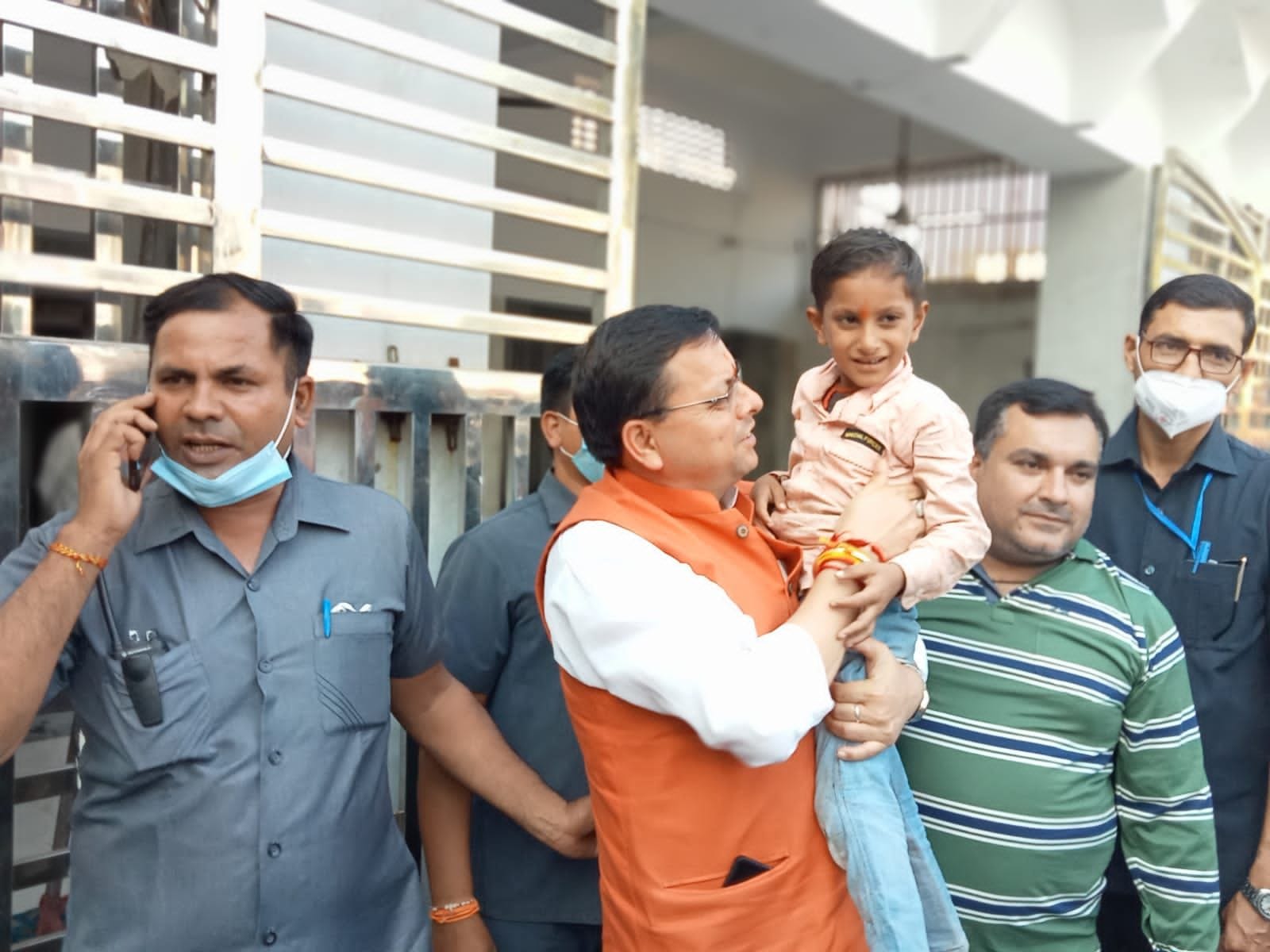 खटीमा में पीलीभीत रोड स्थित हनुमान मंदिर के बाहर बच्चे को गोद में उठाए सीएम धामी।