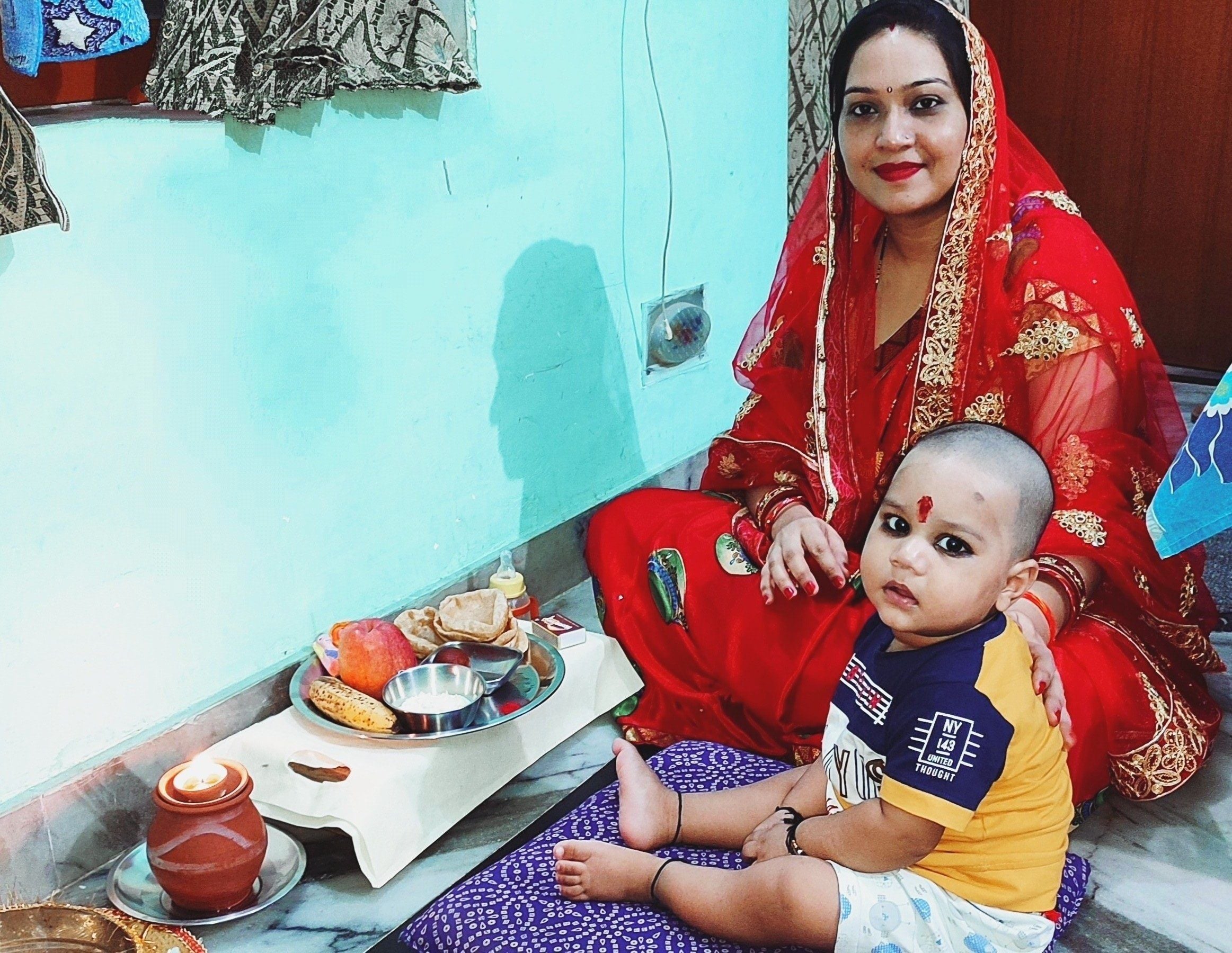 अहोई अष्टमी पर अहोई माता की पूजा करती महिला साथ बेटा अंश । अहोई अष्टमी पर अहोई माता की पूजा करती महिला साथ बेटा अंश ।