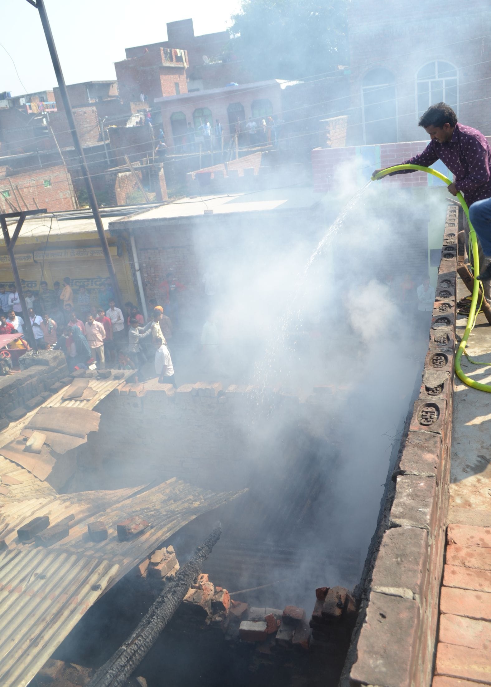 मोहल्ला दरीबा पश्चिम में लगी आग बुझाता पड़ोसी युवक। संवाद मोहल्ला दरीबा पश्चिम में लगी आग बुझाता पड़ोसी युवक। संवाद