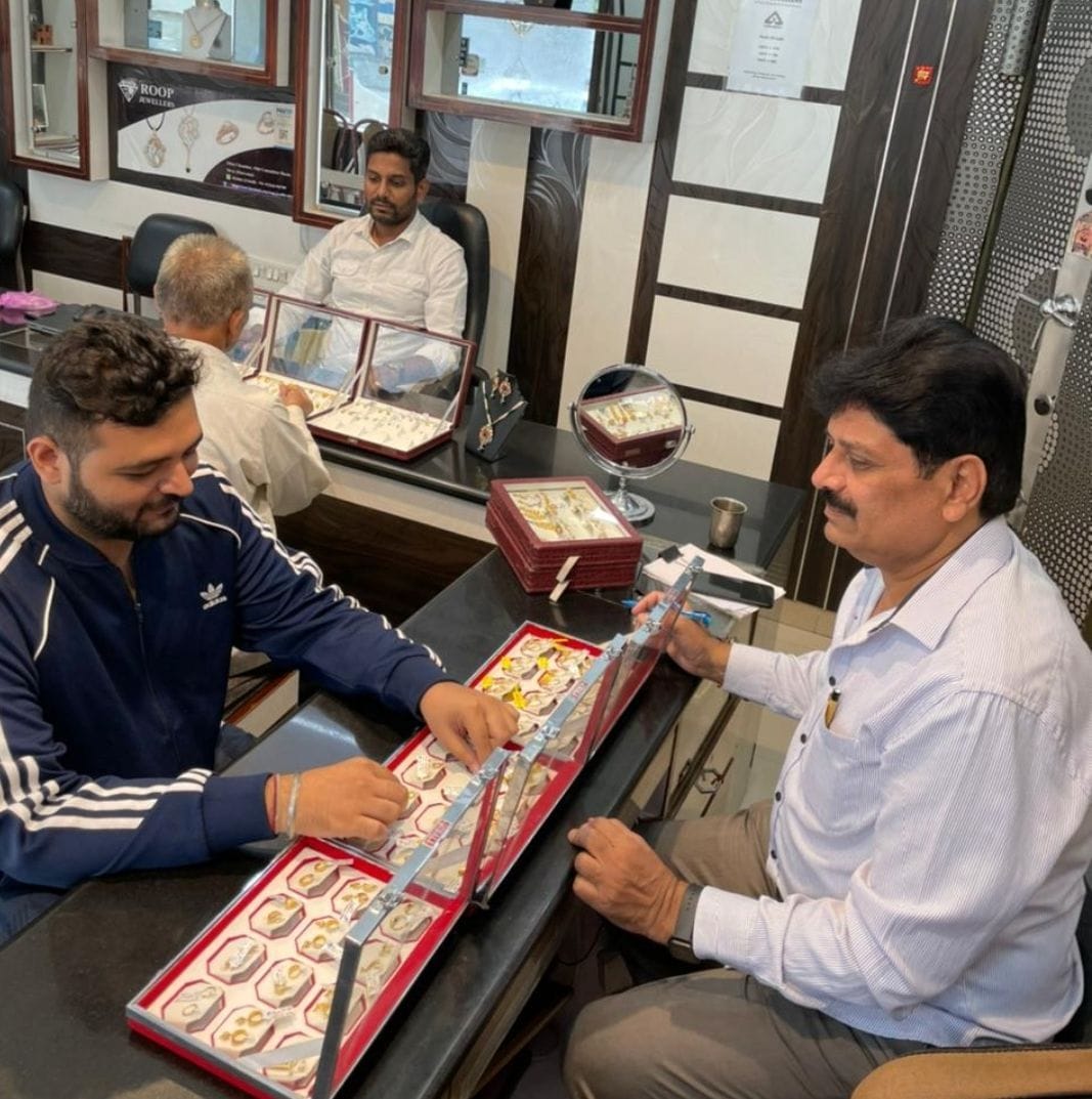 शहर की आभूषणों की दुकान पर आभूषण देखते ग्राहक शहर की आभूषणों की दुकान पर आभूषण देखते ग्राहक
