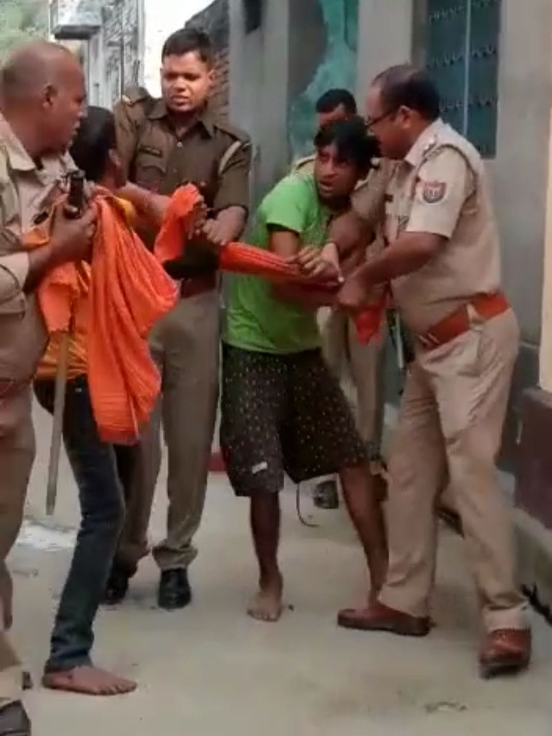 युवक को पीटने वाले पिता-पुत्र को पकड़कर ले जाते पुलिसकर्मी। युवक को पीटने वाले पिता-पुत्र को पकड़कर ले जाते पुलिसकर्मी।