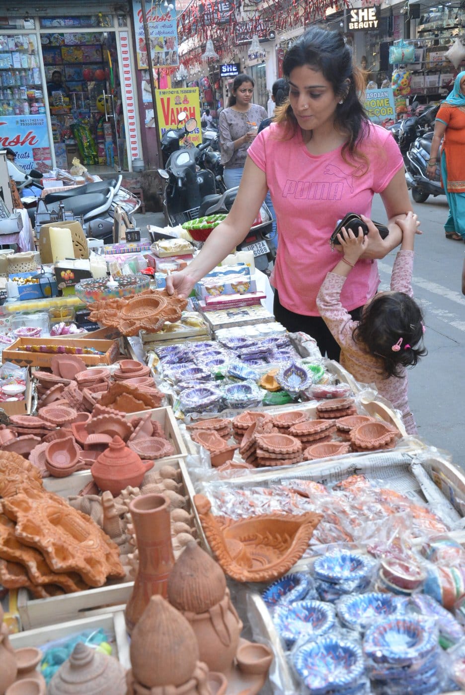 मुजफ्फरनगर में दीपावली पर्व पर मिटटी के दीये खरीदती महिला।