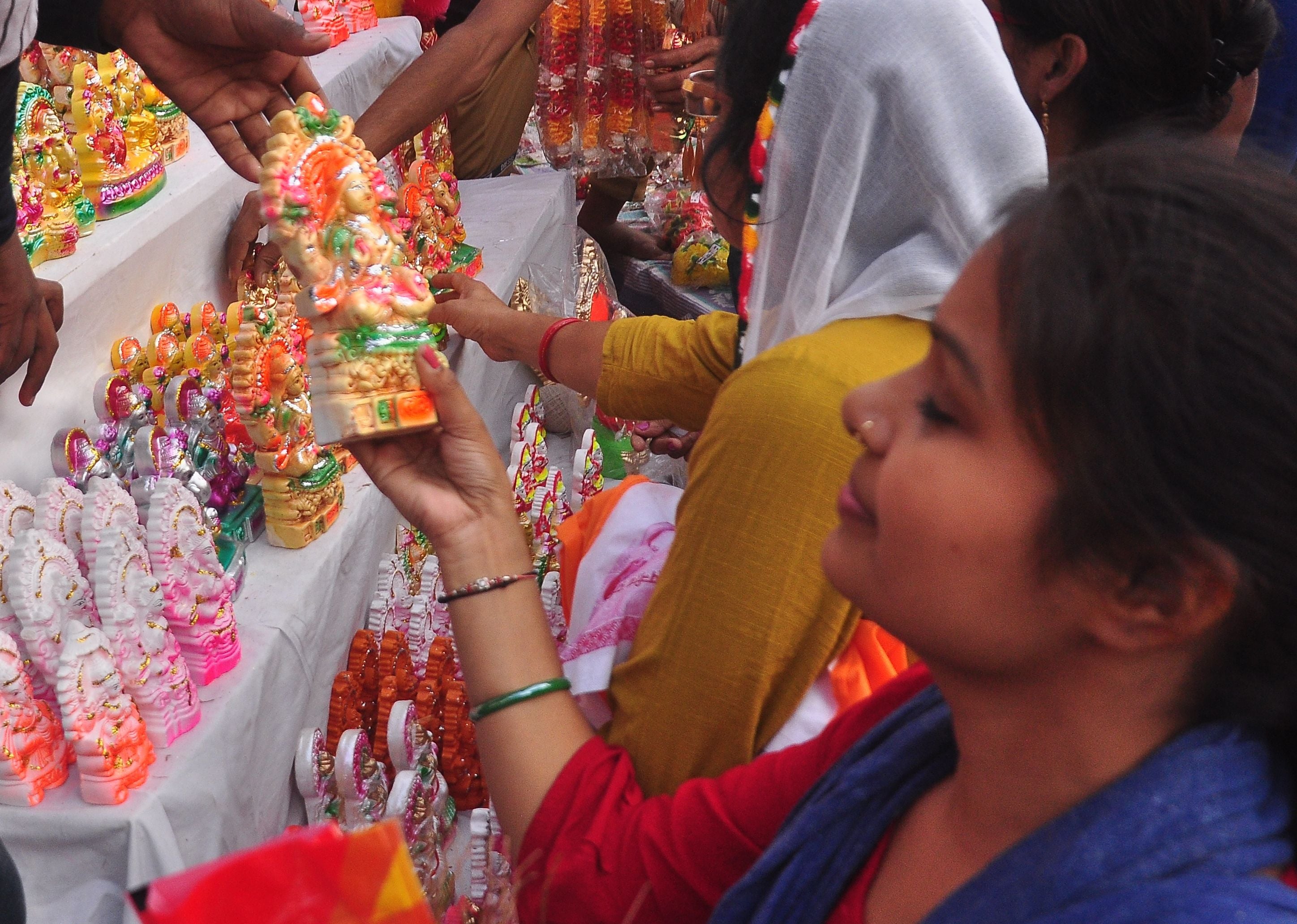 चौक में लक्ष्मीजी की प्रतिमा खरीदती युवती। संवाद