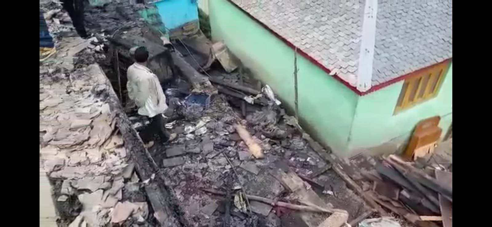 गुवाड़ी पंचायत के भडोगा में आग लगने के बाद जले सामान व घर को देखता व्यक्ति।