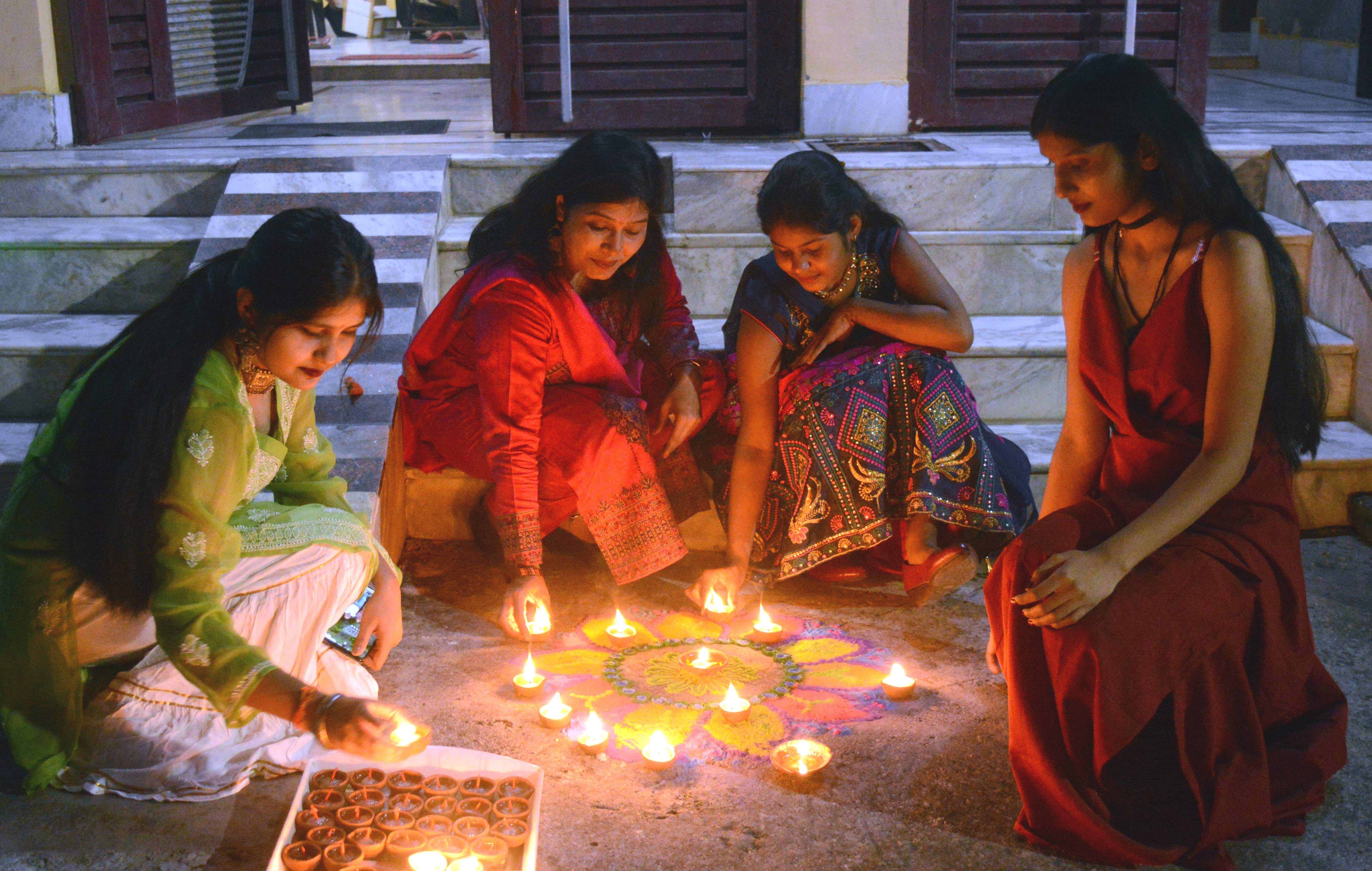 रामपुर में दिवाली पर घर के आगे रंगोली बनाकर दीये जलाती महिला व युवतियां। संवाद रामपुर में दिवाली पर घर के आगे रंगोली बनाकर दीये जलाती महिला व युवतियां। संवाद