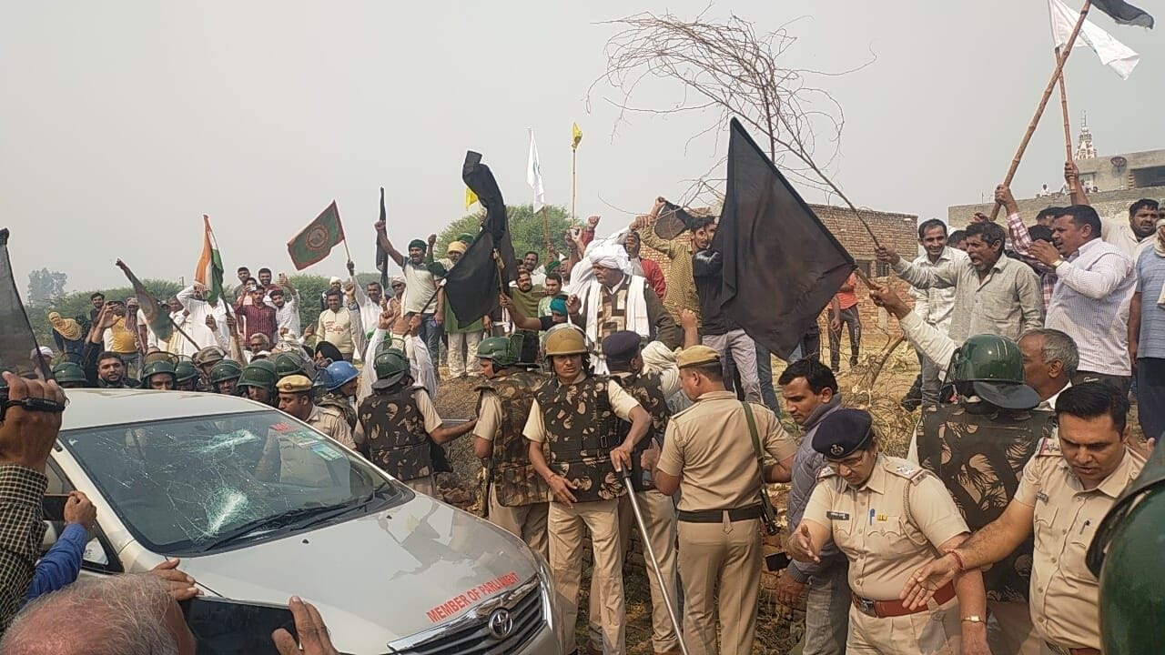 नारनौंद में राज्यसभा सदस्य रामचंद्र जांगड़ा को काले झंडे दिखाते किसान बीच में पुलिस बल