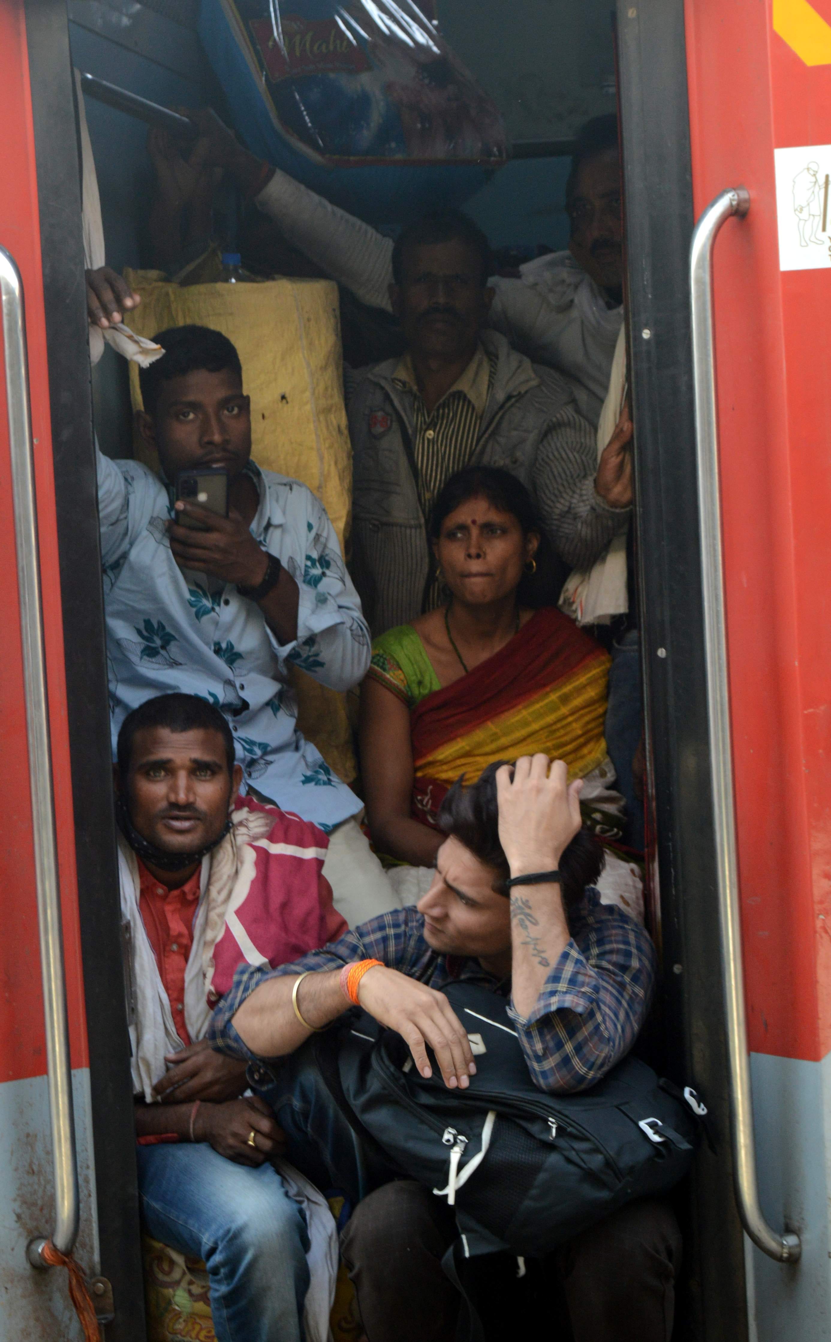 रामपुर में रेलवे स्टेशन पर ट्रेन में गेट पर बैठकर सफर करते यात्री। संवाद रामपुर में रेलवे स्टेशन पर ट्रेन में गेट पर बैठकर सफर करते यात्री। संवाद