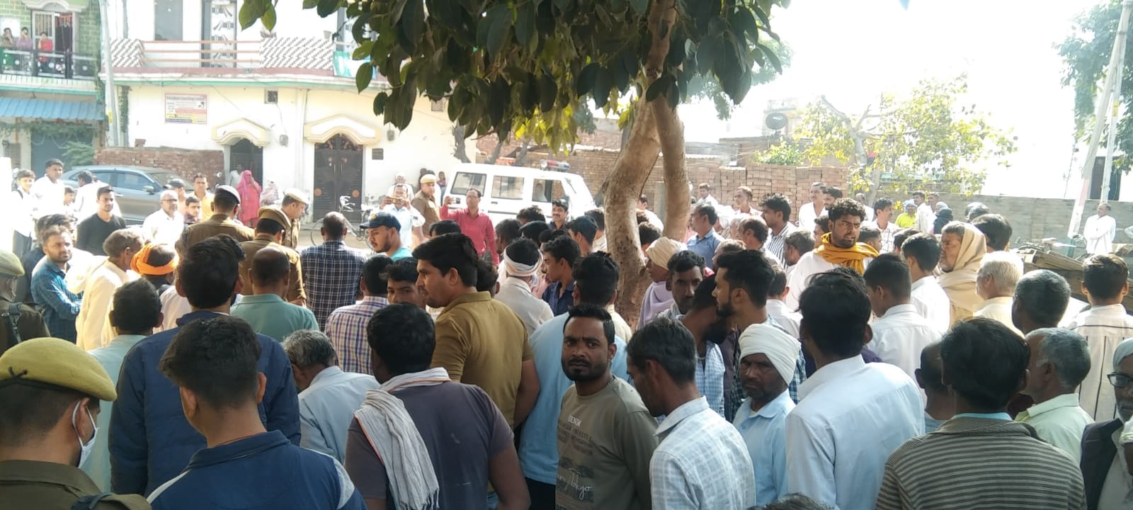 जानसठ के गांव तालड़ा में मोहित सैनी की हत्या को लेकर गांव मौजूद ग्रामीण और पुलिस बल।