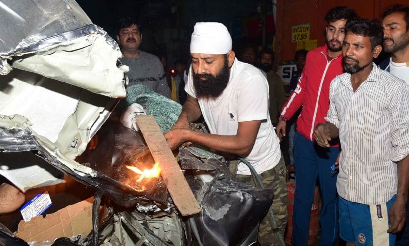 क्षतिग्रस्त वाहन को गैस कटर से काटते व्यापारी रिंकू नामधारी।