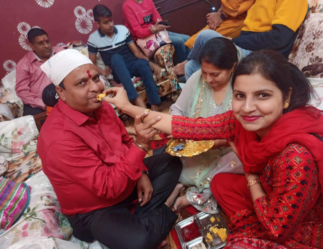 भावना अपने भाई प्रवेश का मुंह मीठा करवाते हुए।
