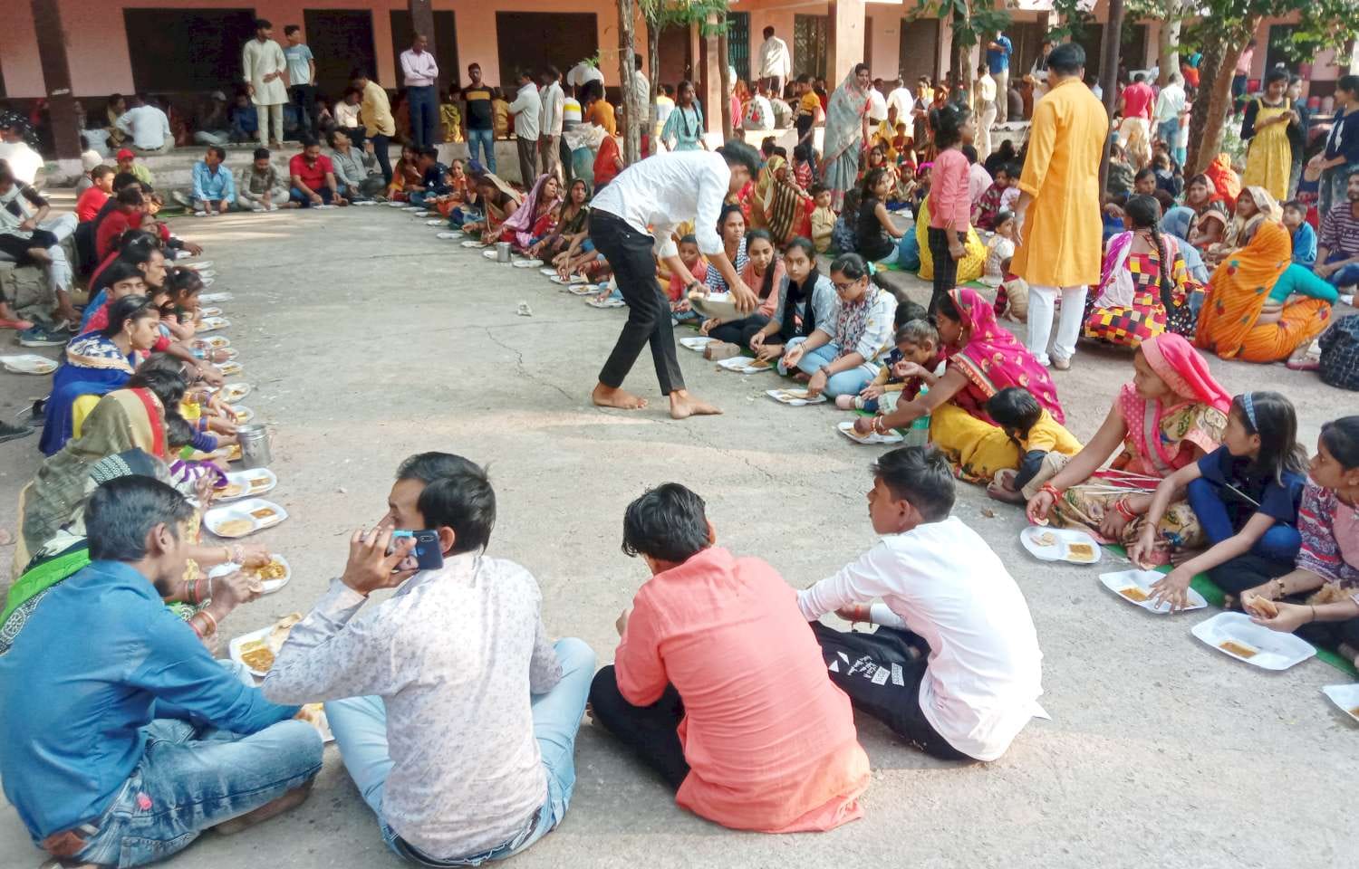 अन्नकूट भोज में प्रसाद ग्रहण करते भक्त। अन्नकूट भोज में प्रसाद ग्रहण करते भक्त।