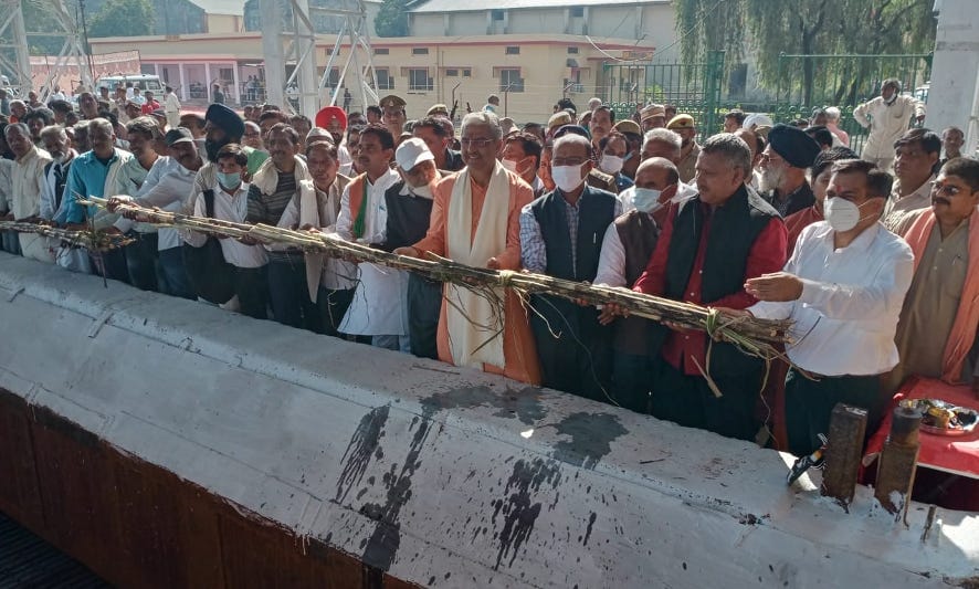 नजीबाबाद चीनी मिल पेराई सत्र पर चेन में गन्ना डालते डीएम और जनप्रतिनिधि।
