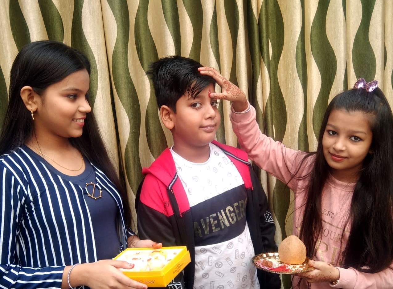 रामपुर में भैया दूज पर भाई को टीका करती बहन। संवाद रामपुर में भैया दूज पर भाई को टीका करती बहन। संवाद