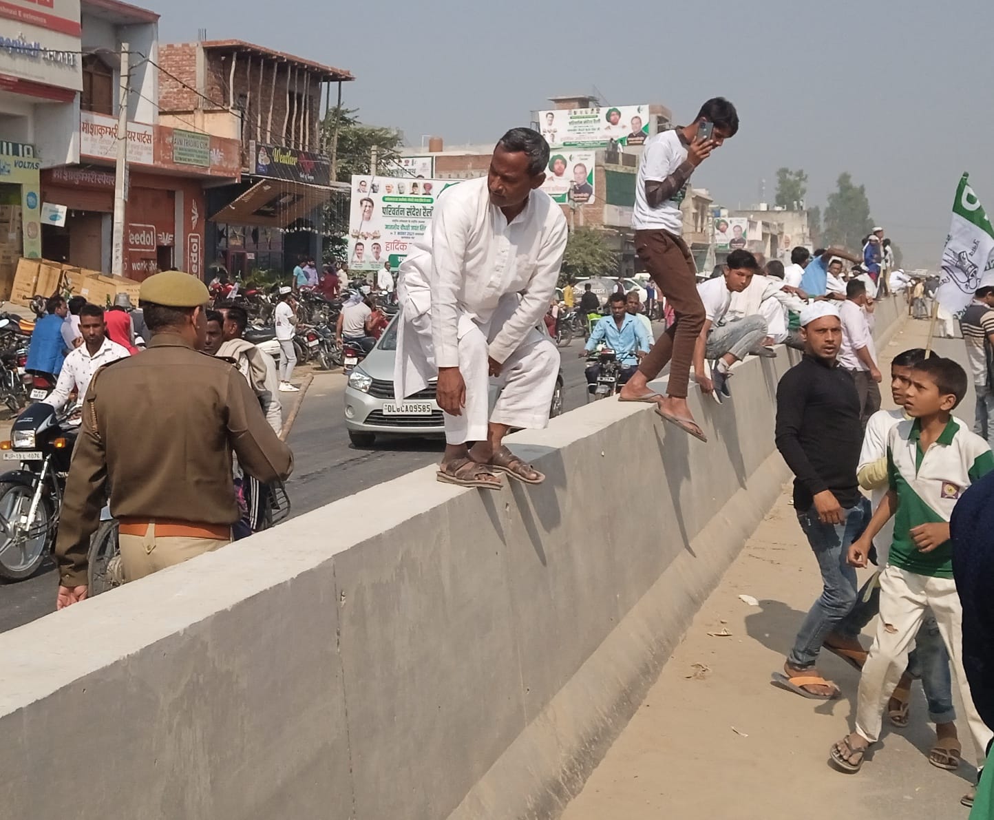 शामली : थानाभवन में रालोद की परिवर्तन संदेश रैली के दौरान डिवाइडर पर खडे़ लोगों हटाता पुलिसकर्मी?