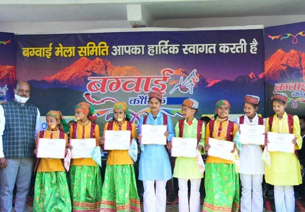 मेले में कलाकारों को सम्मानित करते समिति के लोग। 