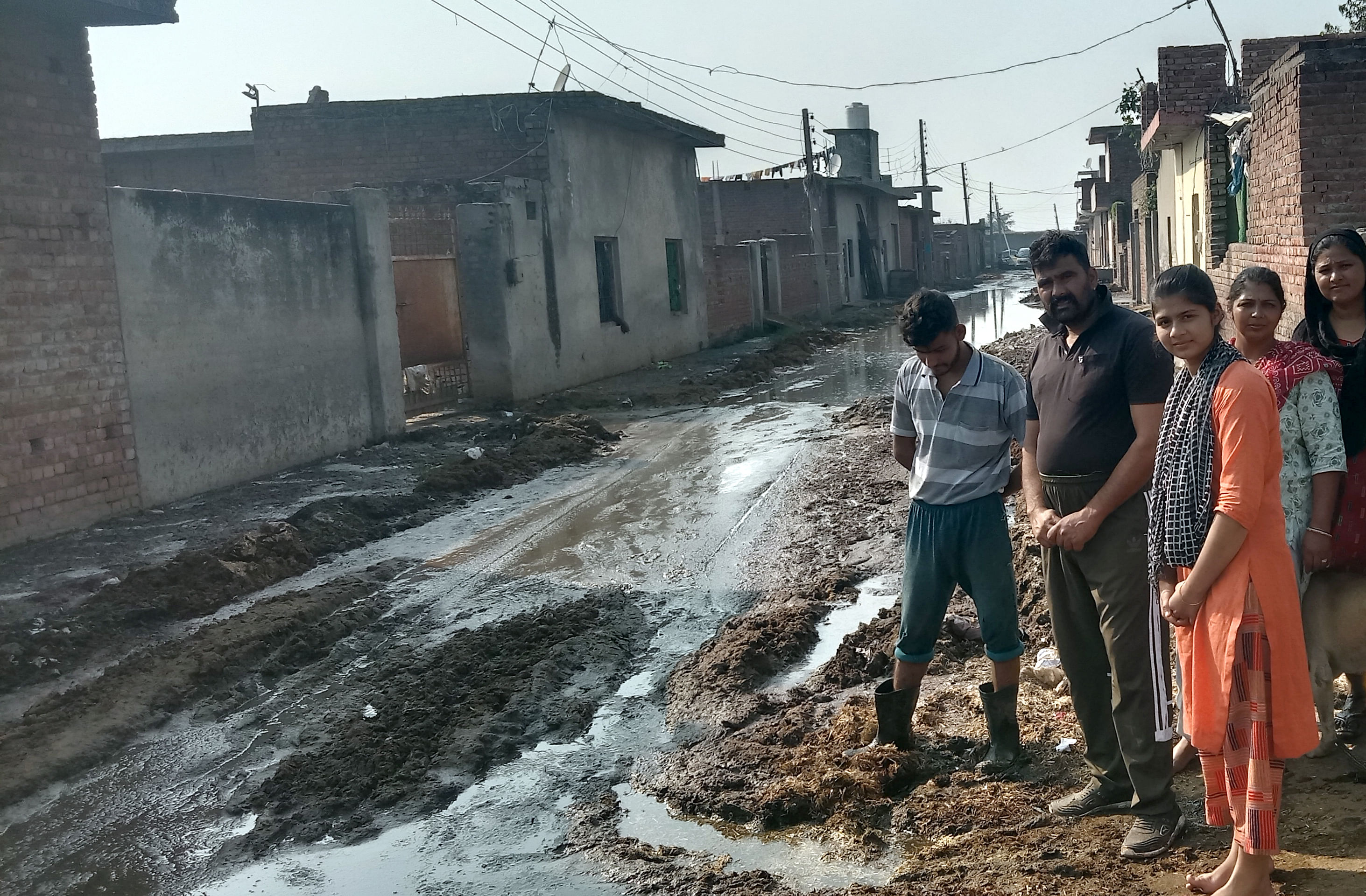Warga menunjukkan kotoran dan air kotor yang disimpan di Dairy Complex, Khatauli, Ambala.