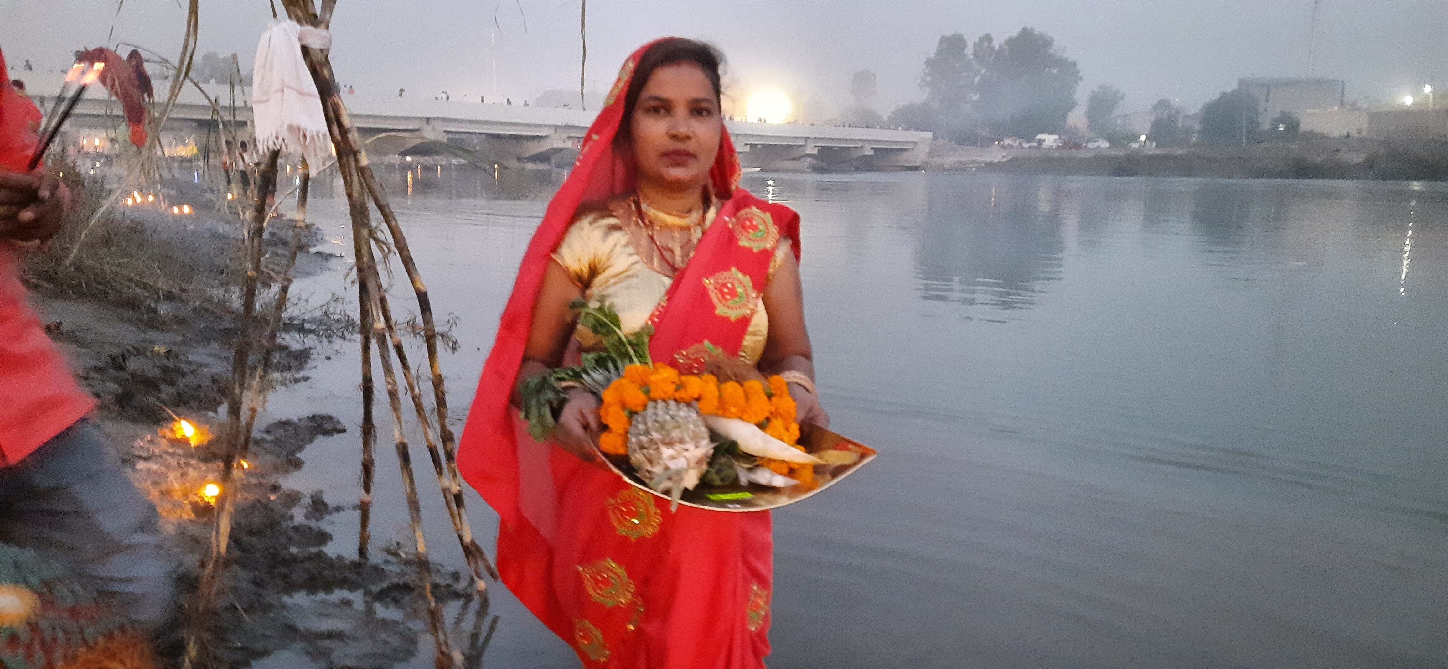  छठ पूजन के दौरान अस्ताचलगामी सूर्य को अर्घ्य देती श्रद्धालु महिला।   संवाद