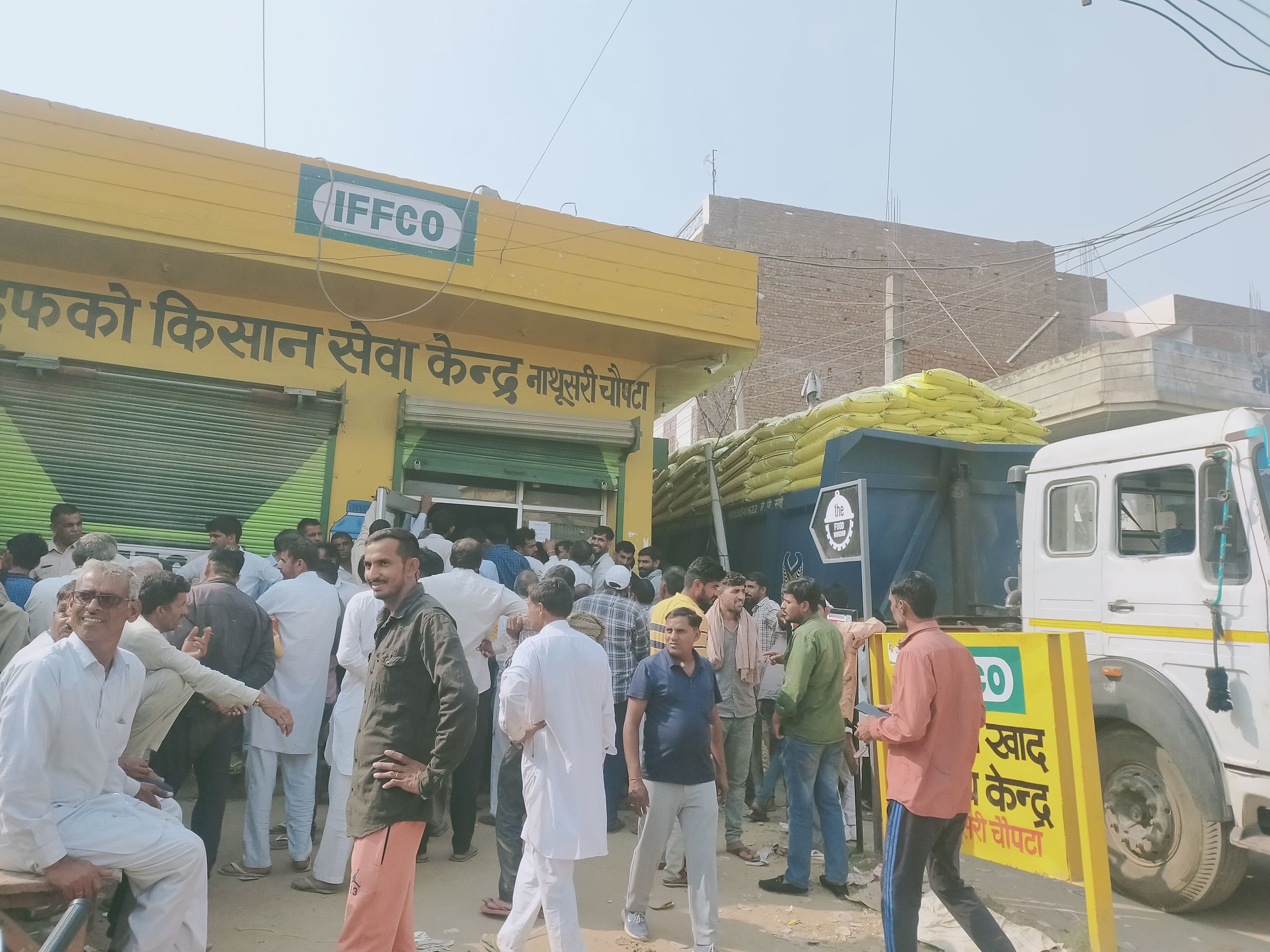डीएपी खाद लेने के लिए इफको खाद केंद्र पर खड़े किसान।