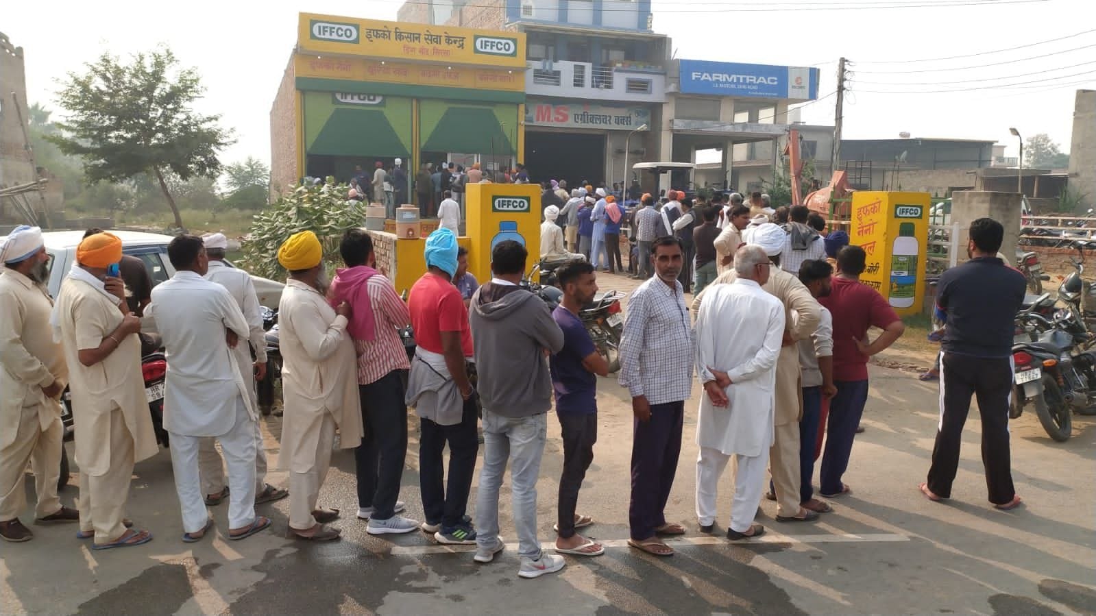 डिंग इफकों केंद्र के बाहर डीएपी लेने के लिए लगी किसानों की लंबी लाइन
