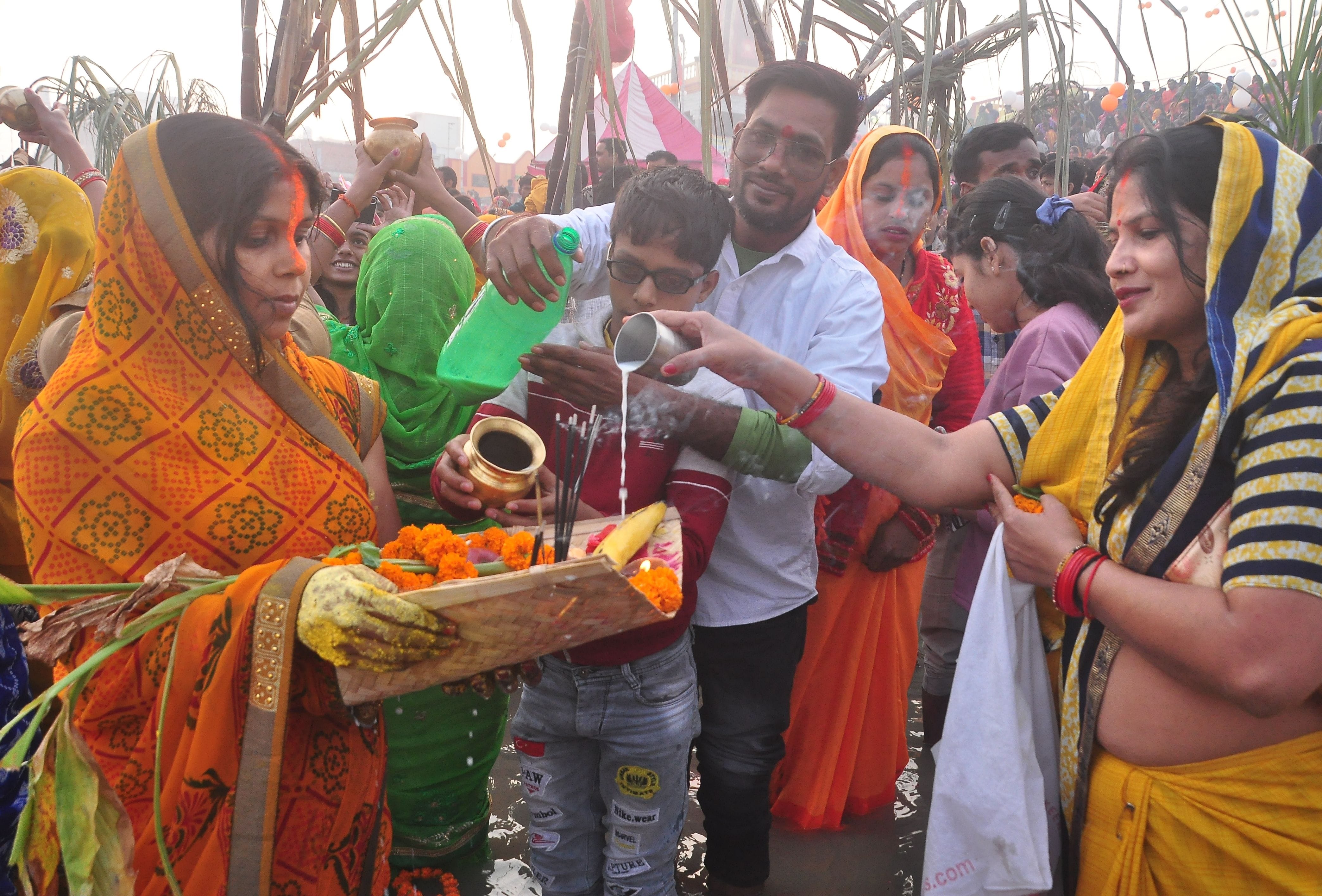 वृहस्पतिवार को डाला छठ के मौके पर सूर्योदय के दौरान अर्घ देता परिवार। संवाद