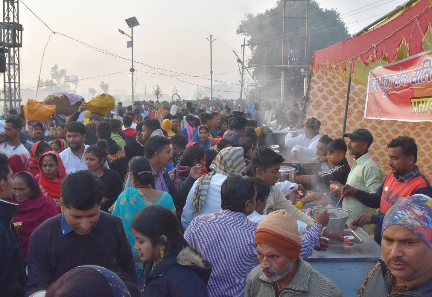 बड़ी नहर पर छठ पूजा के दौरान लोगो को प्रसाद वितरित करते संघ कार्यकर्ता