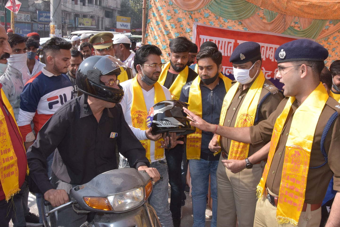 घंटाघर पर यातायात महा के तहत एकटिवा सवार चालक को हेलमेट प्रदान करते पुलिस अधिकारी व व्यापारी घंटाघर पर यातायात महा के तहत एकटिवा सवार चालक को हेलमेट प्रदान करते पुलिस अधिकारी व व्यापारी