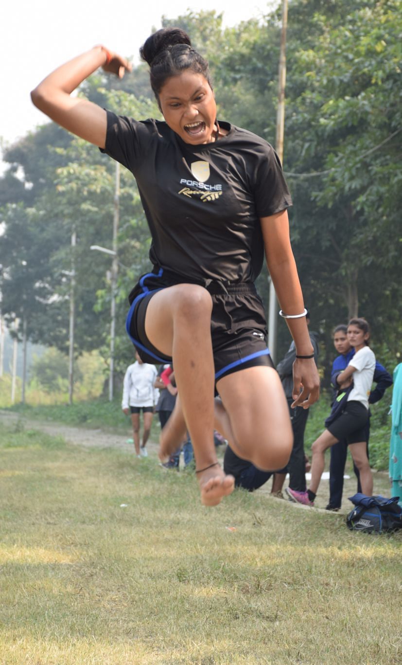 Gadis yang berpartisipasi dalam kompetisi lompat jauh di Stadion Rudrapur.