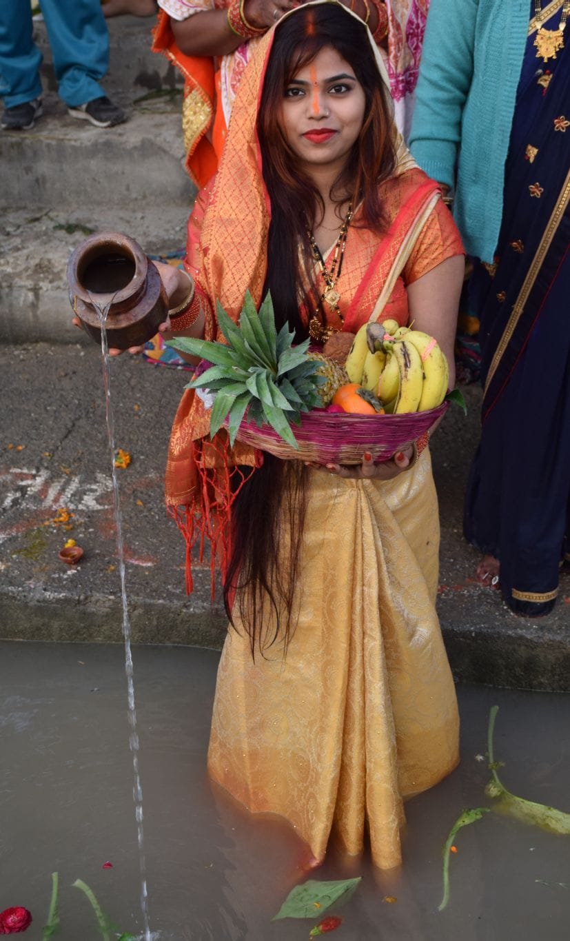 रुद्रपुर के छठ पूजा घाट पर उगते सूर्य को अर्घ्य देती महिला।