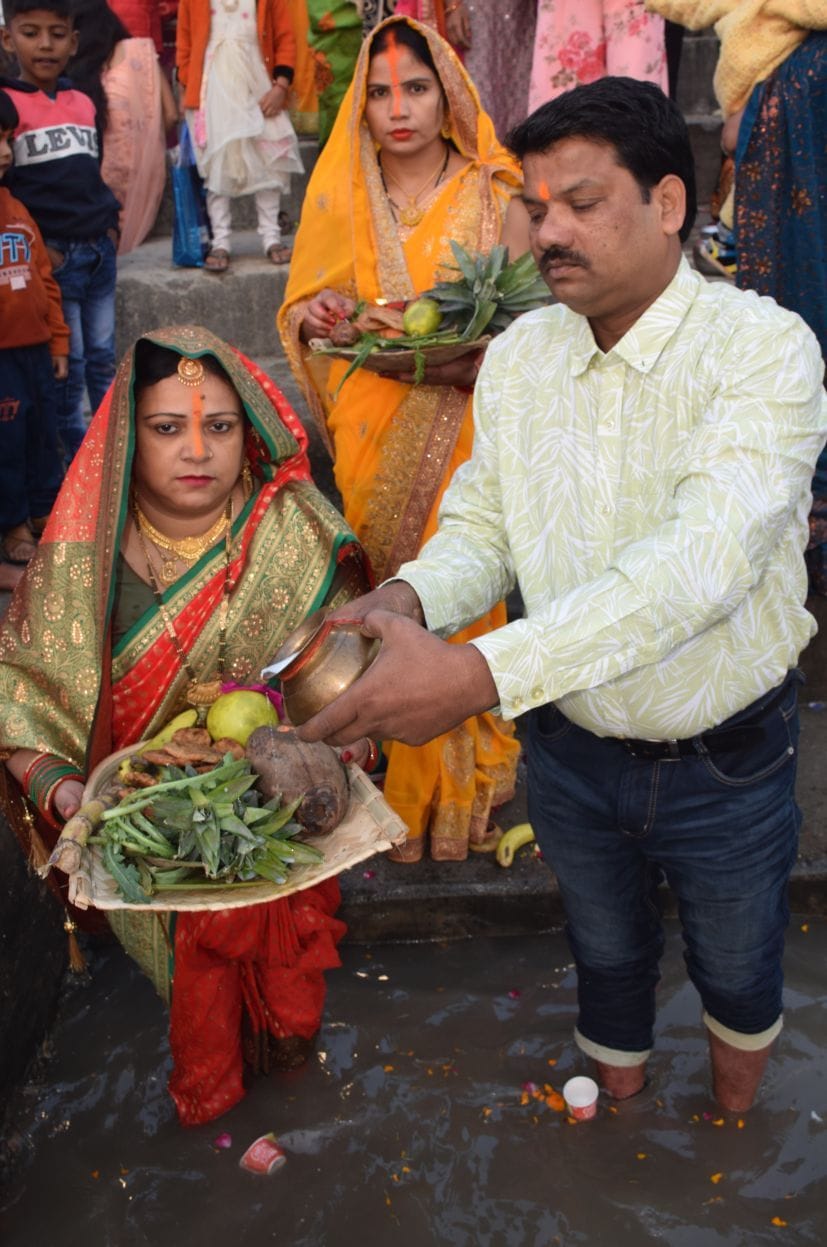 रुद्रपुर के छठ पूजा घाट पर उगते सूर्य को अर्घ्य देता दंपती।