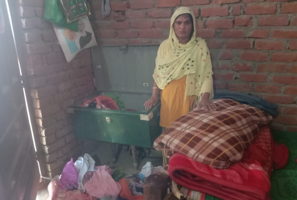 आदमपुर में लूट की घटना के बाद बिखरा सामान दिखाती पुलिस महिला।