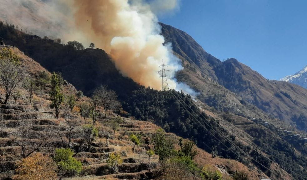 भरमौर के सांह पंचायत में गौशाला में लगी आग से उठता धुंआ।