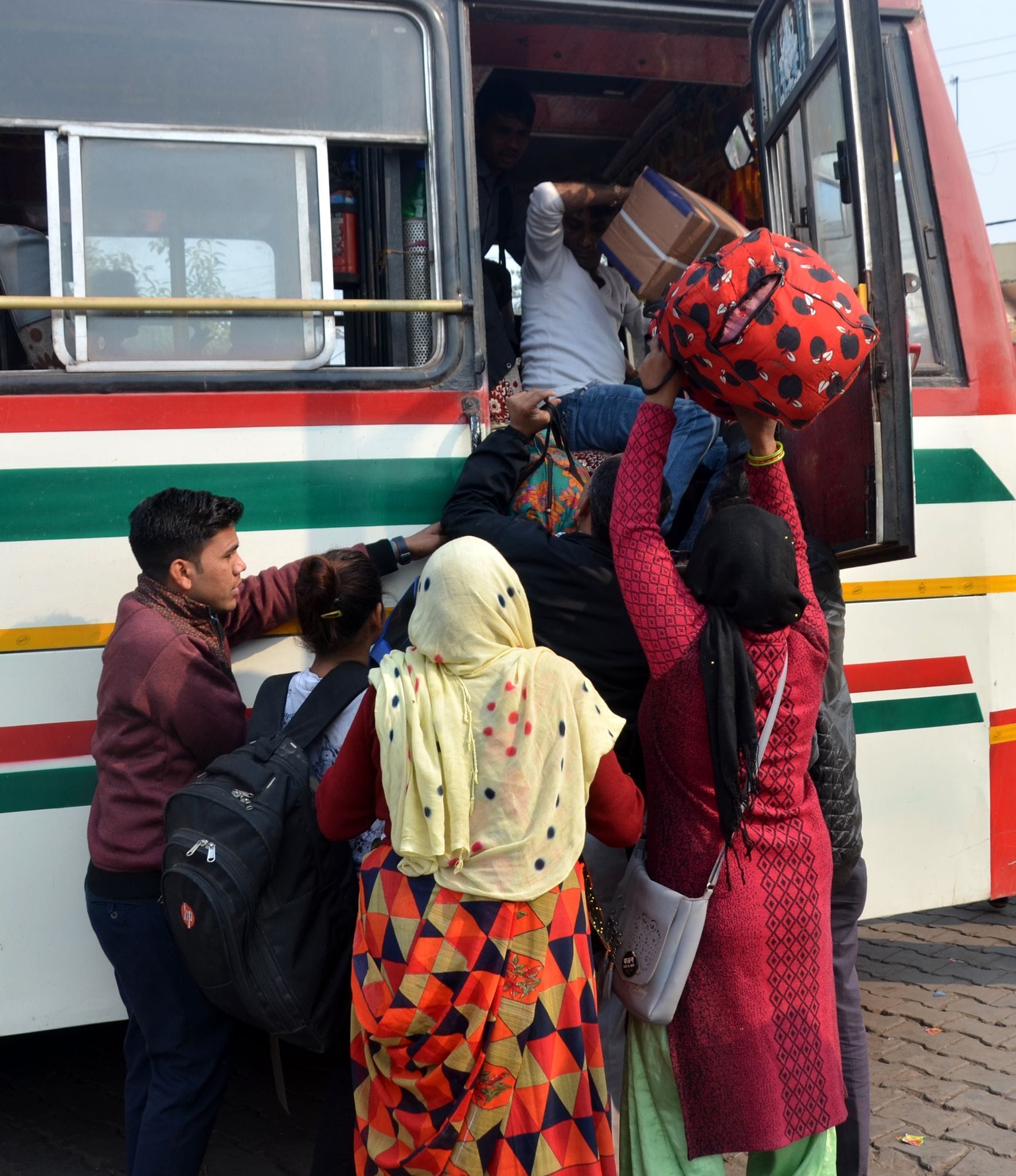 गांधी पार्क बस स्टैंड पर धक्कामुक्की कर बस में चढ़ते यात्री।