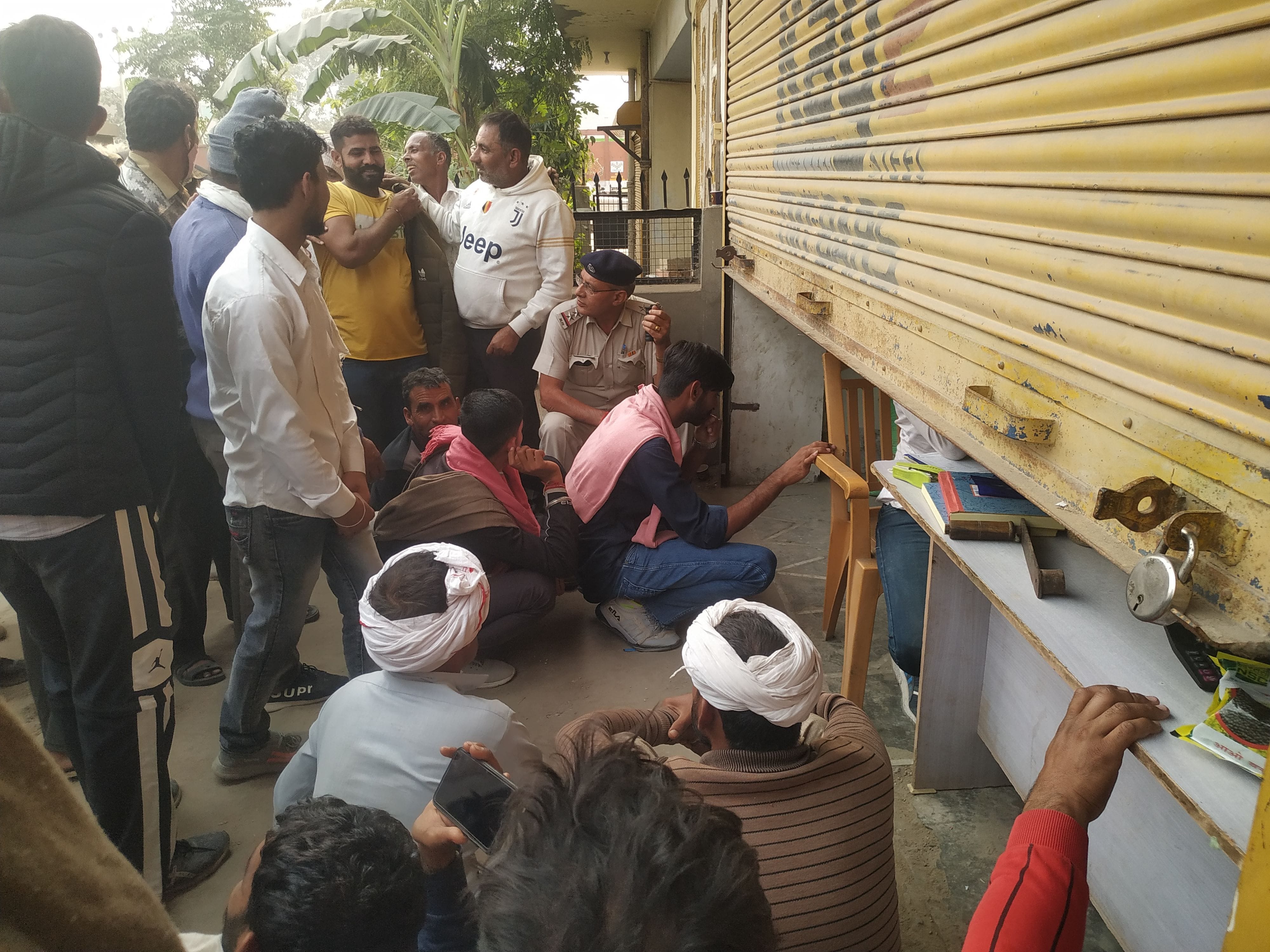 डीएपी लेने के लिए दुकान के बाहर बैठकर इंतजार करते किसान डीएपी लेने के लिए दुकान के बाहर बैठकर इंतजार करते किसान