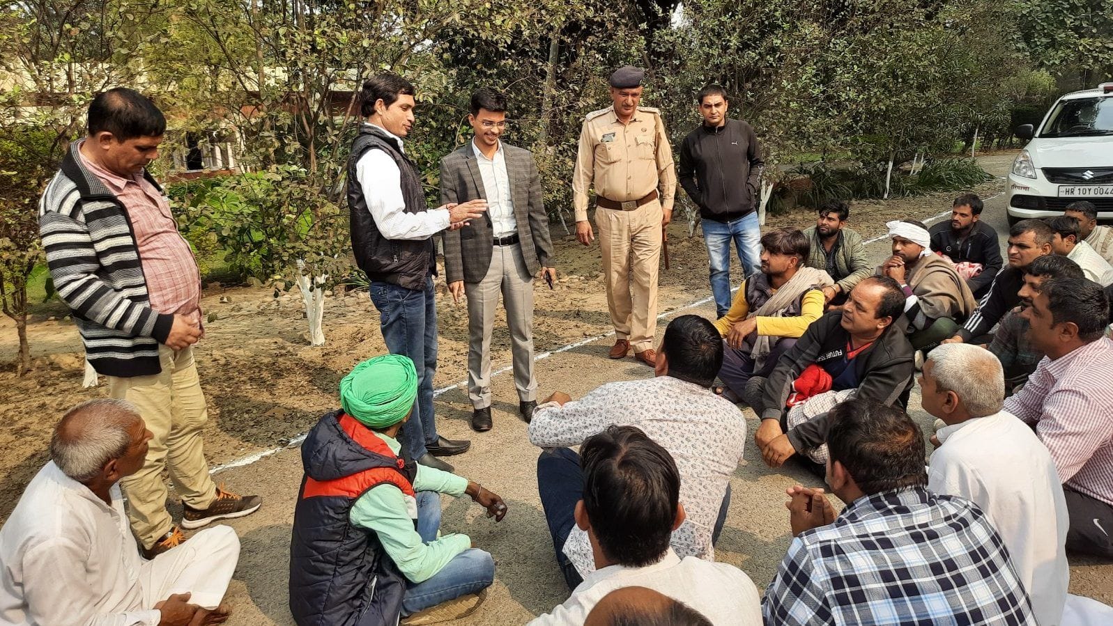 चीनी मिल में कार्यालय के बाहर बैठे किसानों को समझाते प्रबंध निदेशक जितेंद्र जोशी। संवाद