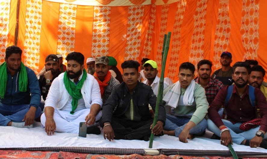 नजीबाबाद के चीनी मिल में धरने पर बैठे किसान।