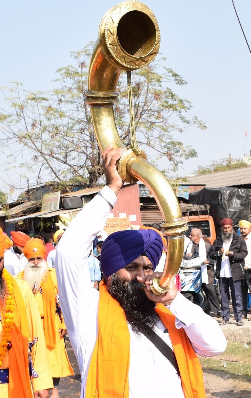 रुद्रपुर में नगर कीर्तन में वाद्ययंत्र बजाता व्यक्ति। रुद्रपुर में नगर कीर्तन में वाद्ययंत्र बजाता व्यक्ति।