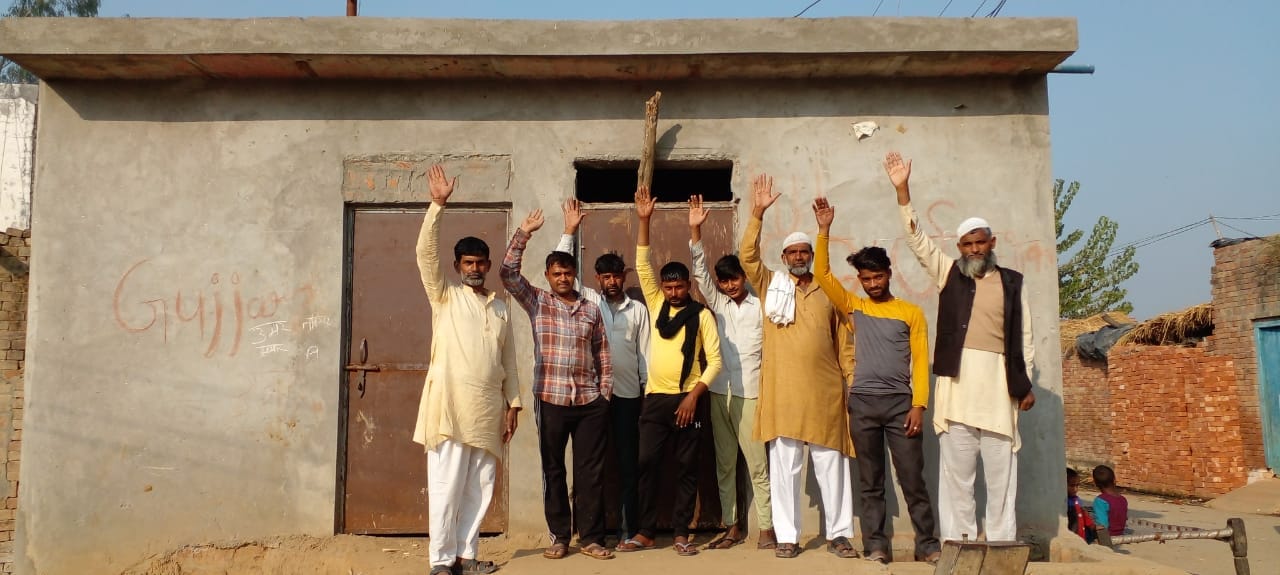 गांव बालू में सामुदायिक शौचालय के निर्माण कार्य को पूरा कराने को प्रदर्शन करते ग्रामीण
